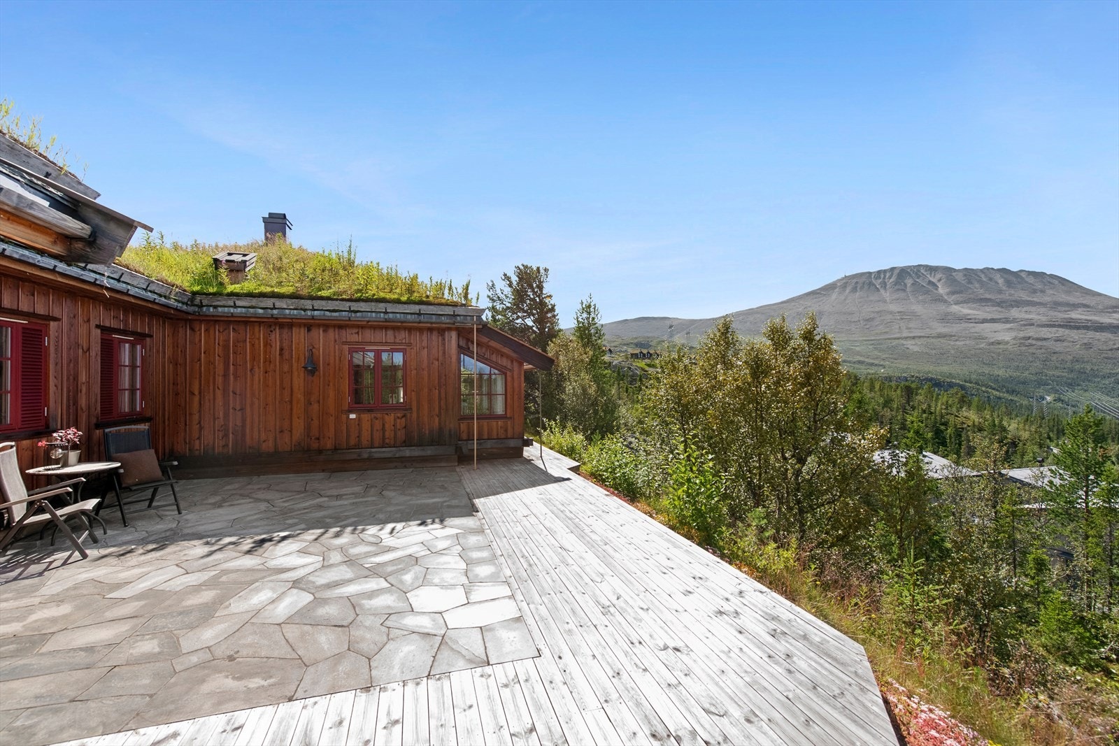 Vestvendt terrasse belagt med skifer, med en spektakulær utsikt mot Gaustatoppen. Galleribilde