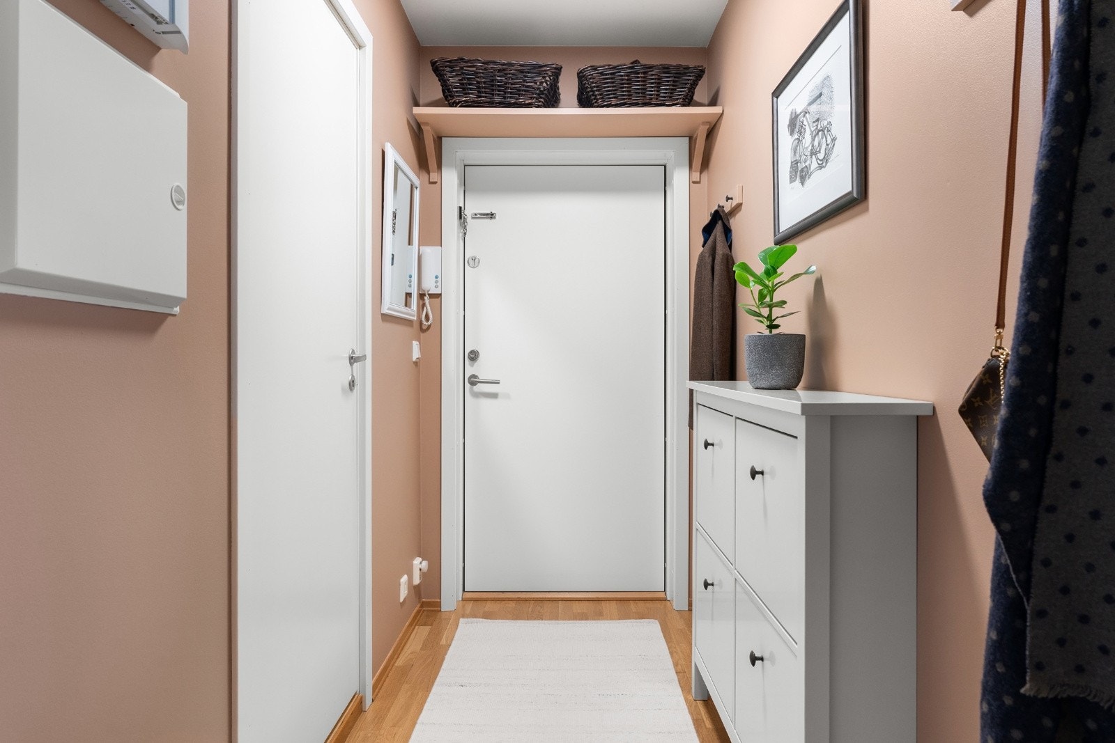 Innbydende entré med plass til oppheng av yttertøy og oppbevaring av sko Galleribilde