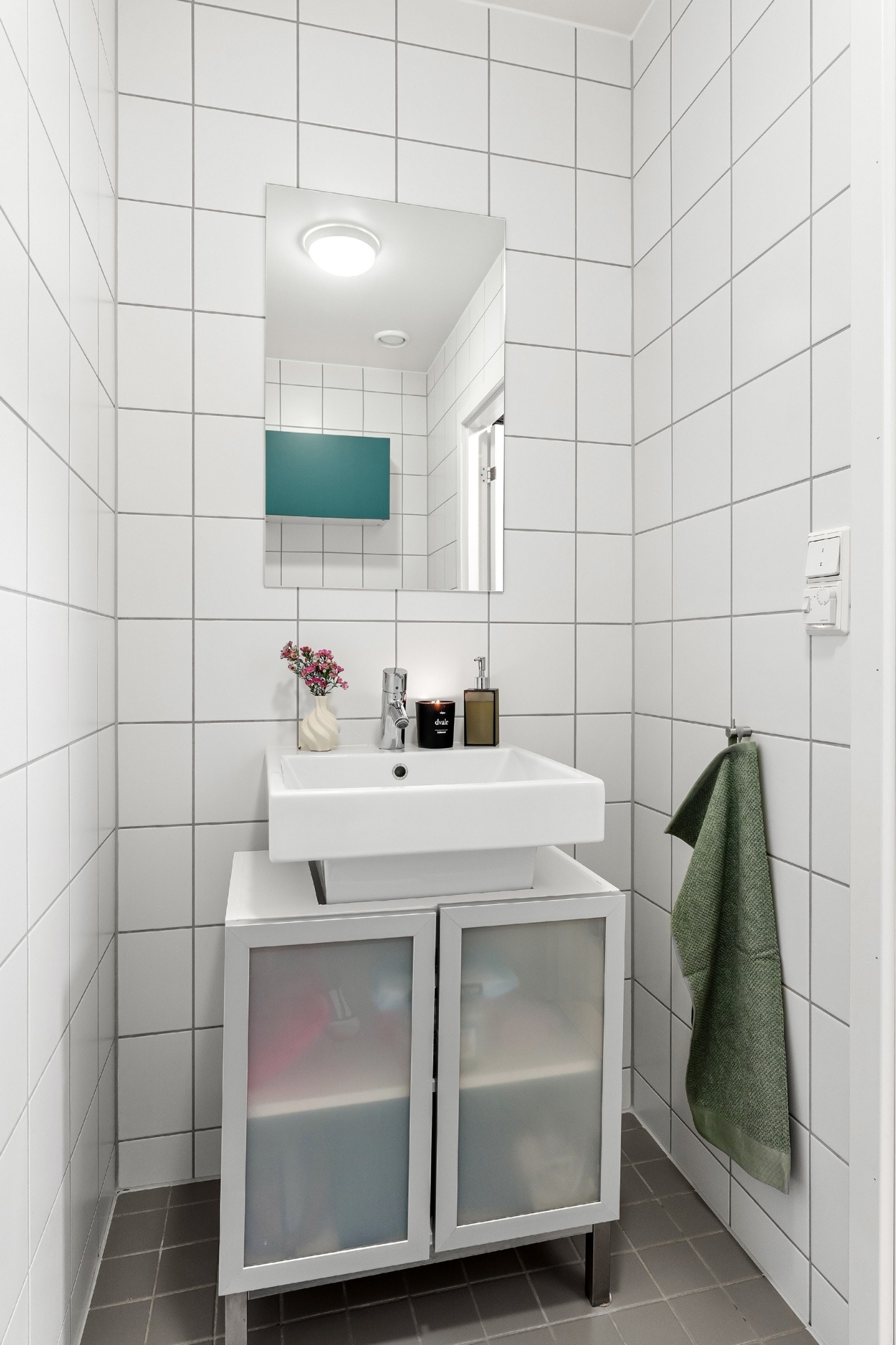 WC-rommet har flislagt gulv med varmekabler, vegghengt toalett og servantskap med oppbevaringsplass Galleribilde