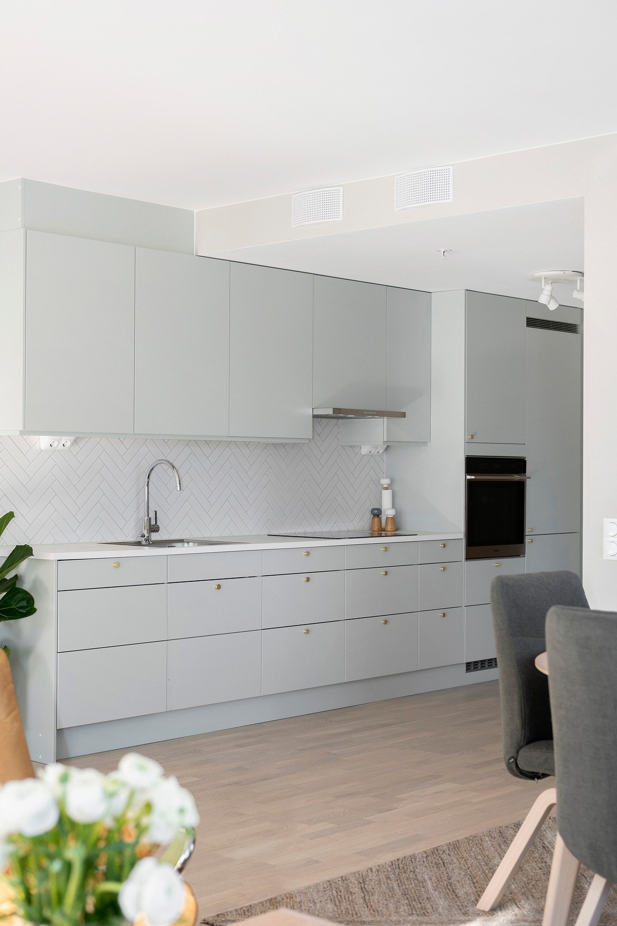 Kjøkkenet har takoppforede, glatte fronter, laminatbenkeplate, stilrent design og integrerte hvitevarer. Galleribilde