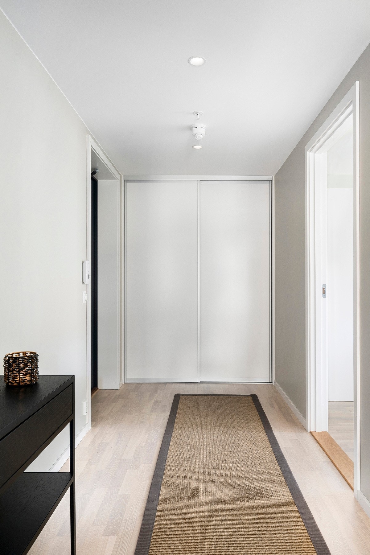 Entreen har downlights og er innredet med en stor skyvedørsgarderobe i endeveggen. Galleribilde