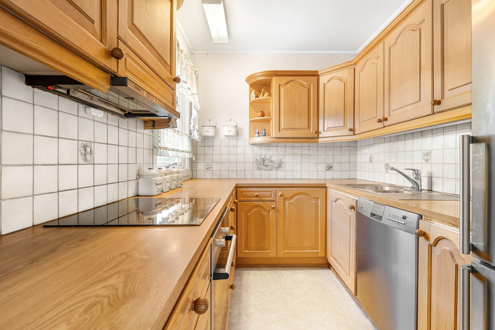 Innredning med profilerte eike-fronter og integrert platetopp. Hvitevarer medfølger. Galleribilde