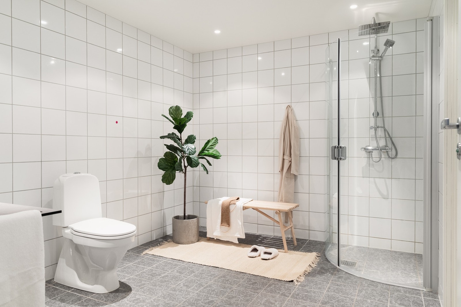 Med effektiv tilkomst fra gangen, kommer man inn til boligens første bad. Badet er helfliset i lyse, tidsriktige farger med varmekabler i gulv. Galleribilde