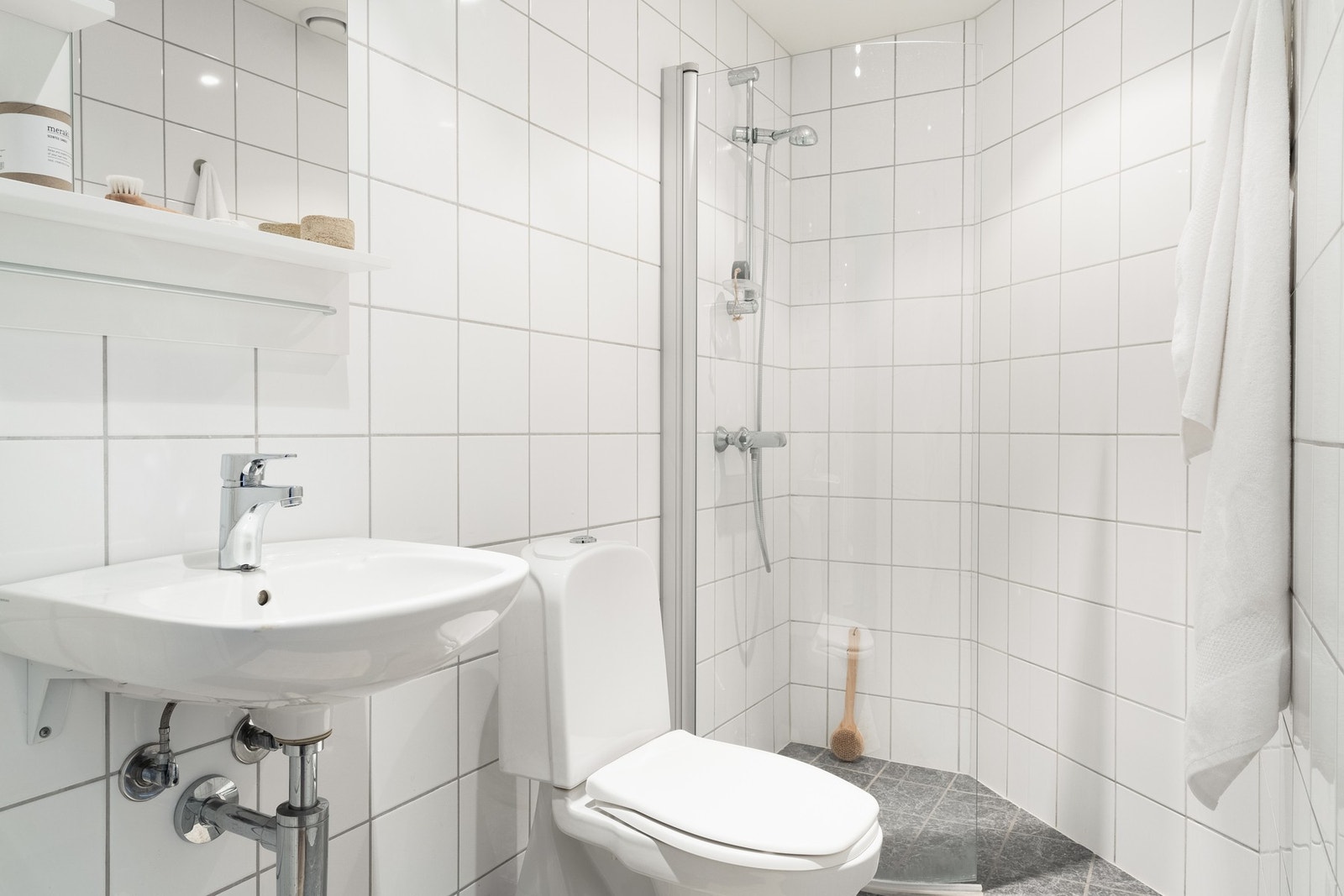 Bad 2 har også tilkomst fra gangen. Badet måler 3 kvm. og er helfliset med varmekabler i gulv. Her er det også spotter i taket, som både er praktisk og stilrent. Galleribilde