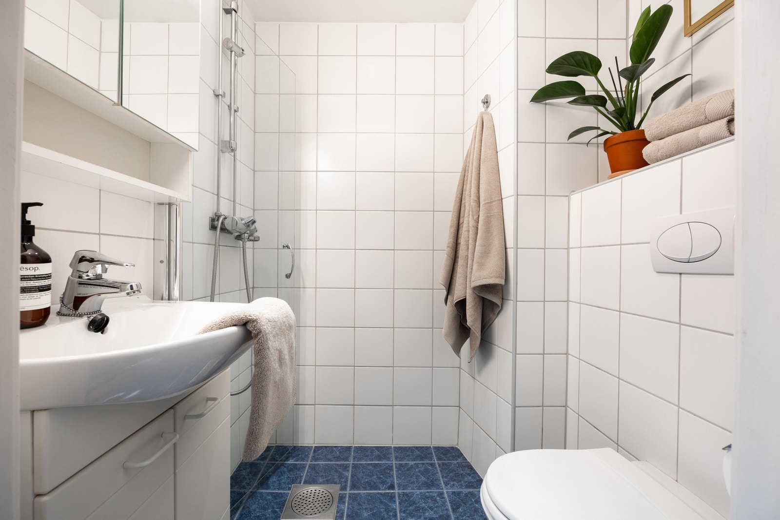 Lyst og pent baderom med flislagt gulv med varme. Galleribilde