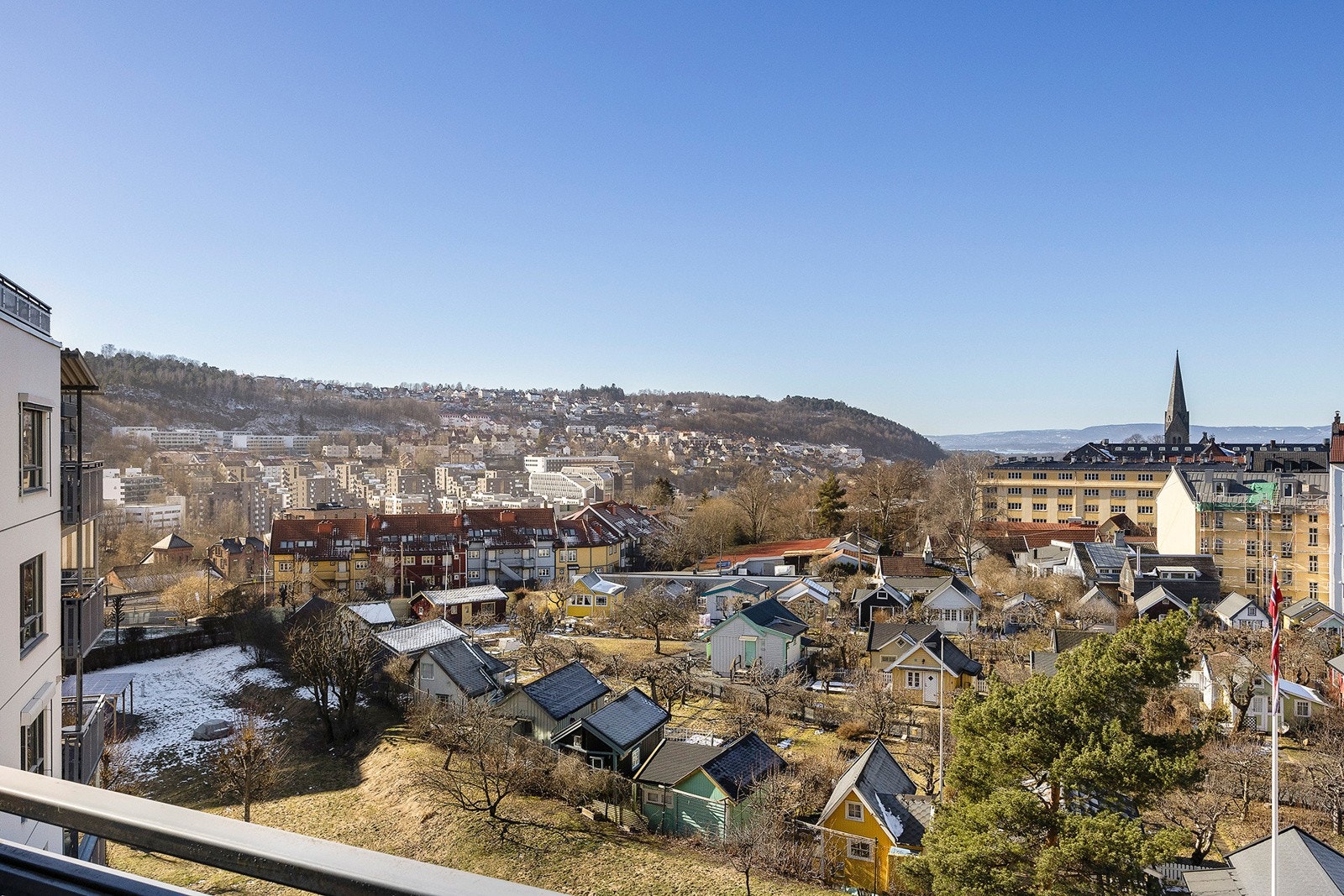 Utsikten fra leiligheten og balkongen er utover idylliske kolonihage og videre utover hele byen og fjorden Galleribilde