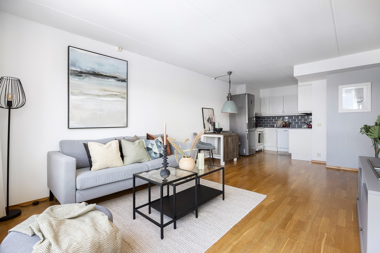 Stue med åpen kjøkkenløsning og plass til både sofagruppe og spisebord Galleribilde