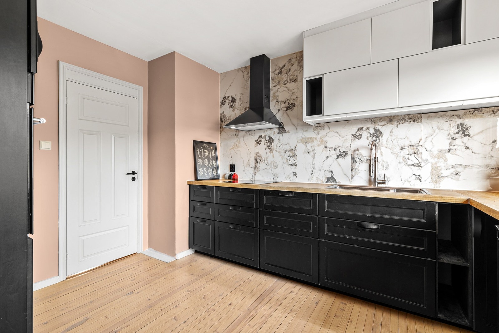 Benkeplaten er av tre og har en nedfelt oppvaskkum med ett-greps kjøkkenarmatur. Det er belysning og stikkontakter montert over kjøkkenbenken Galleribilde