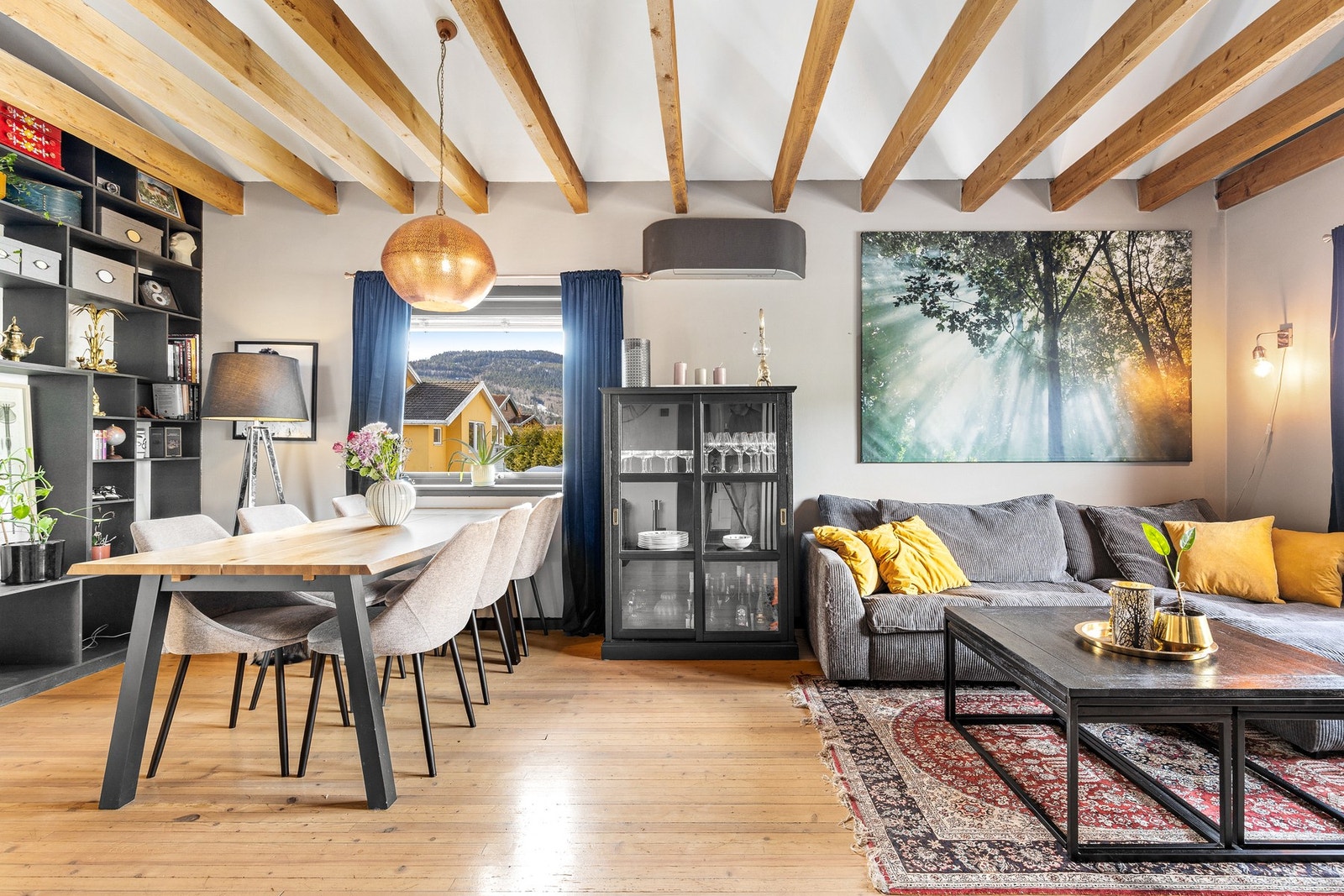 Stilig stue med heltre furugulv, malte flater på vegger og synlige takbjelker i himling Galleribilde