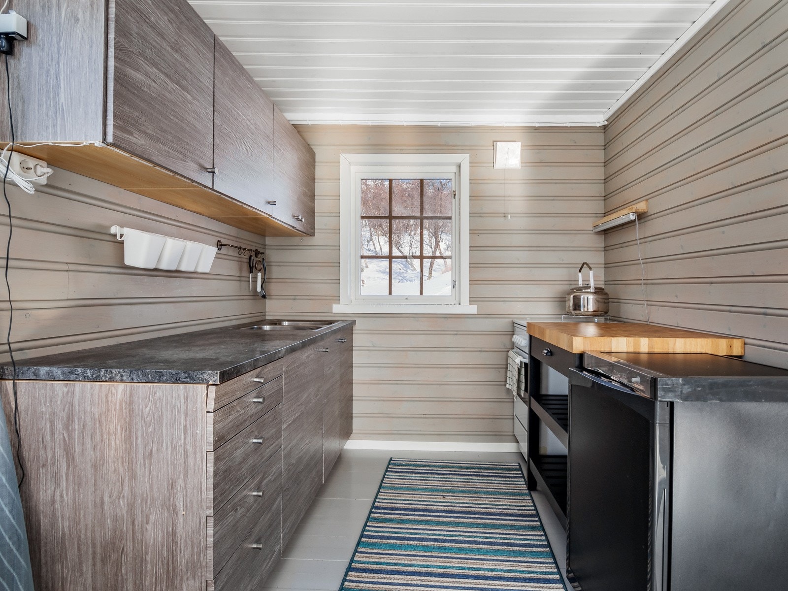 Kjøkkendelen er holdt i samme farger som resten av stua Galleribilde