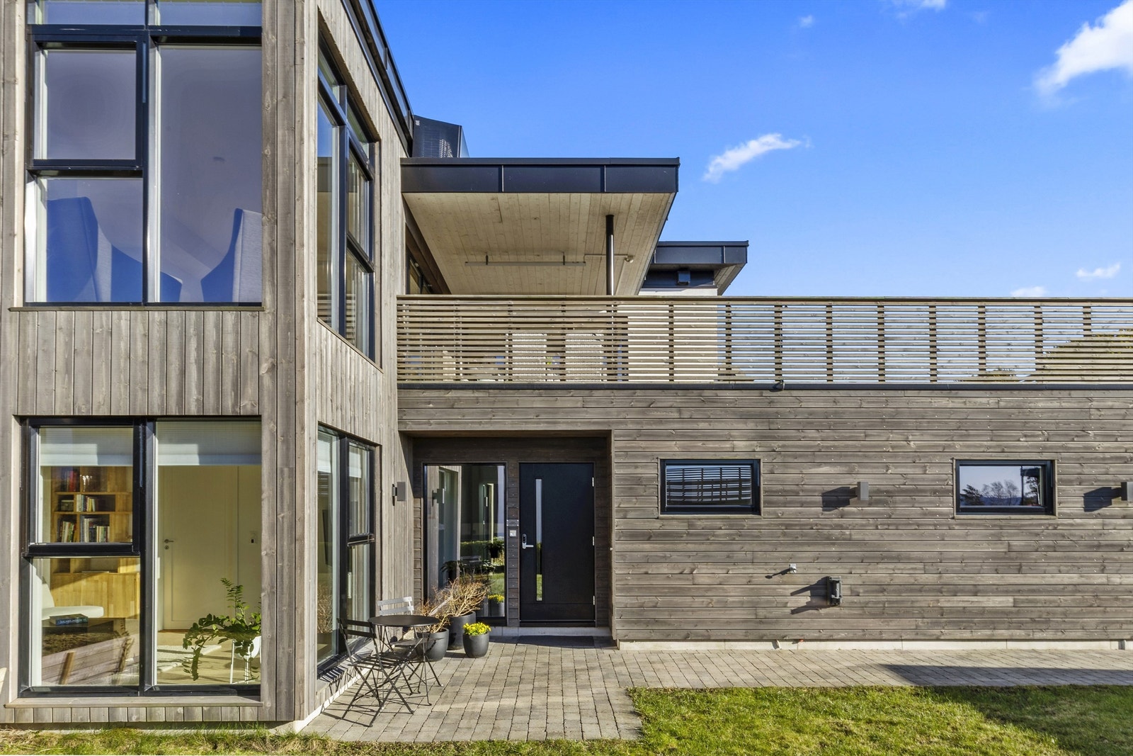 En hyggelig platting utenfor inngangspartiet hvor en kan sitte med kaffekoppen mens barna leker i hagen. Galleribilde