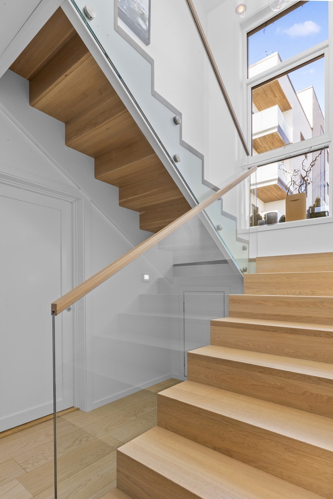 Vi beveger oss opp i 2. etasje. Lys og luftig trappehall med flott trapp i treutførelse, og glassrekkverk med trelist. Galleribilde