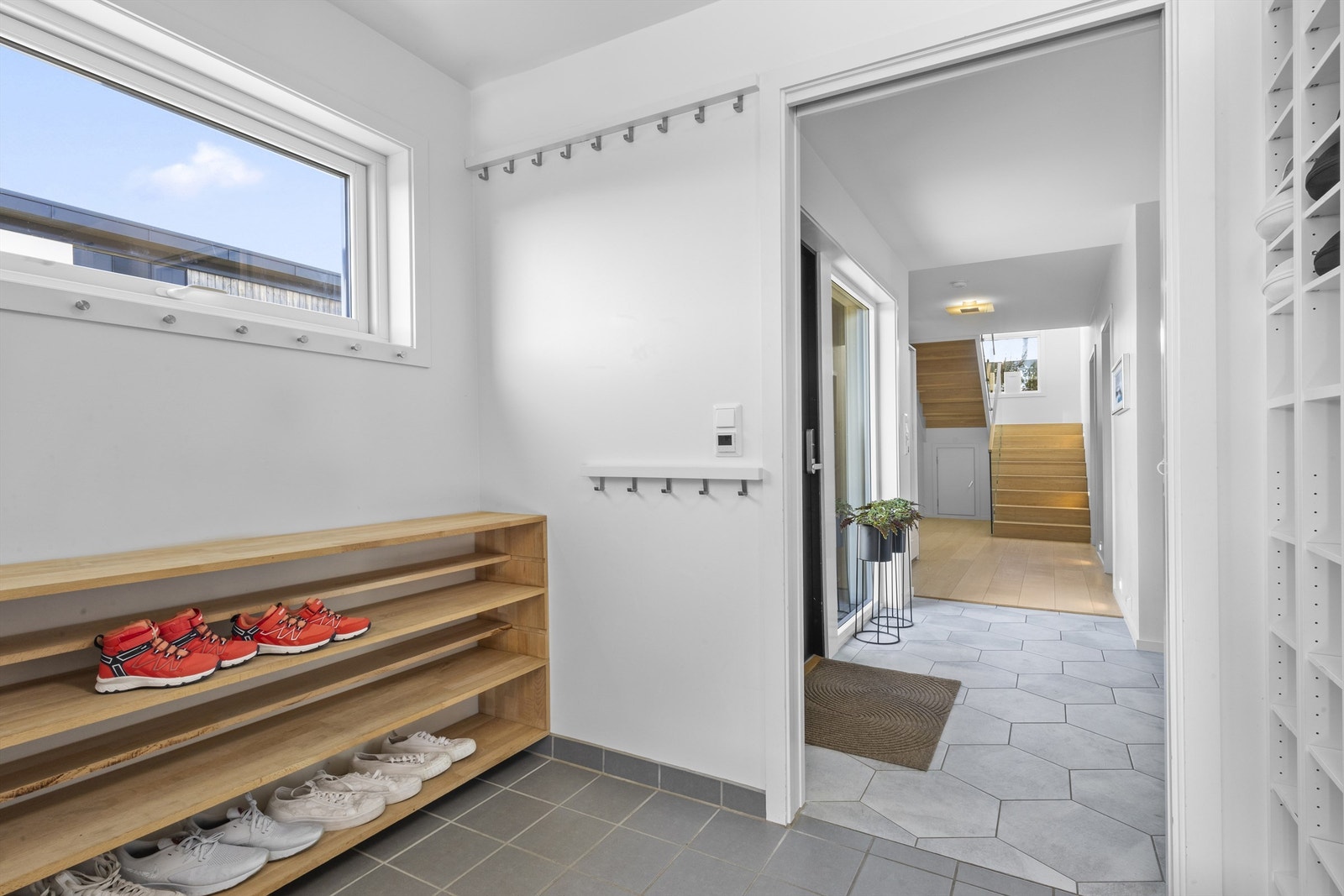 Videre inn fra gangen er det adkomst til vaskerom og videre inn til garasjen. Her kan du altså gå tørrskodd ut til all oppbevaringen som er i garasjen. Det er varmekabler i både gang og vaskerom. Galleribilde