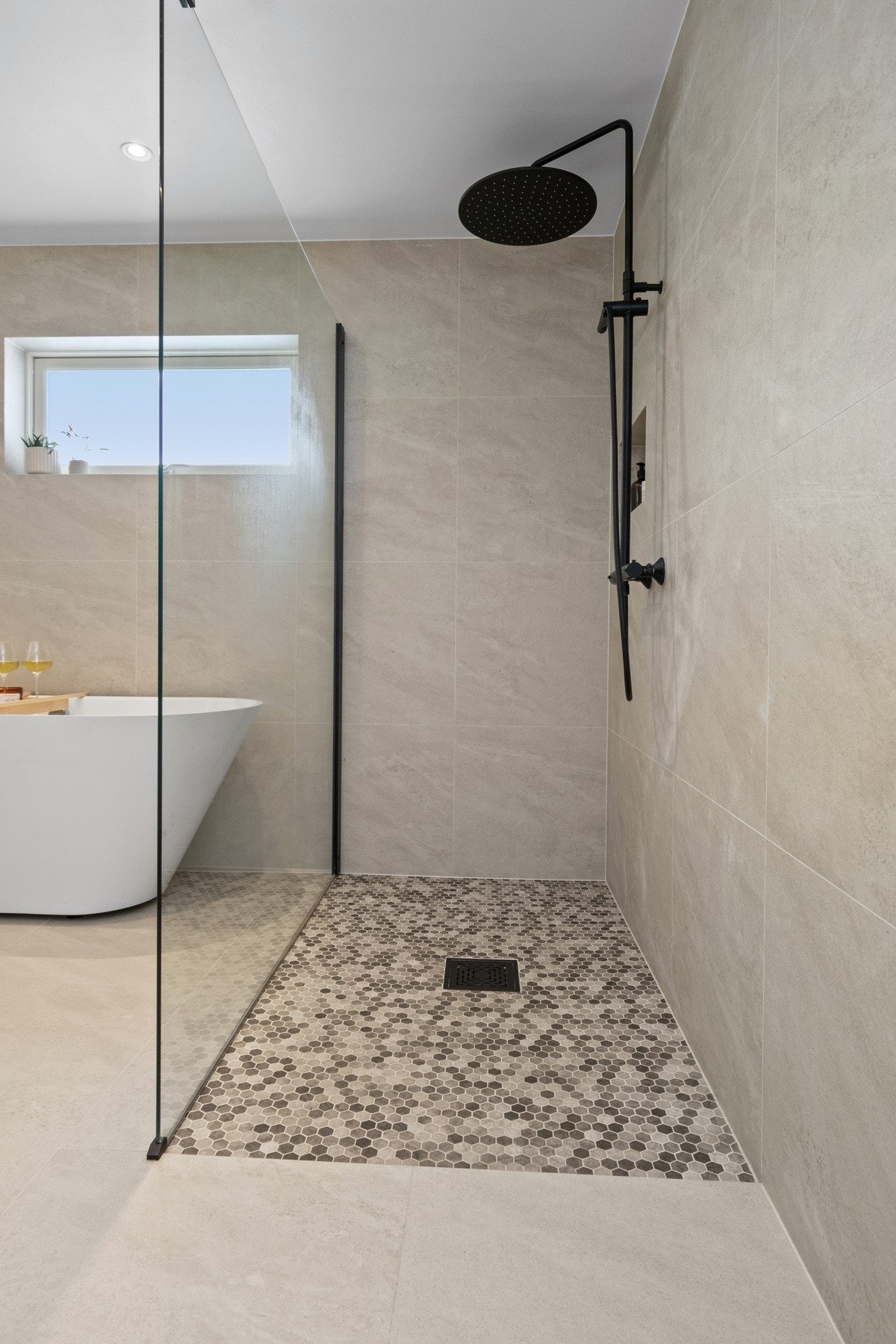 Videre har badet et vegghengt toalett, et stilfullt badekar og et dusjhjørne med regnfallsdusj. Galleribilde