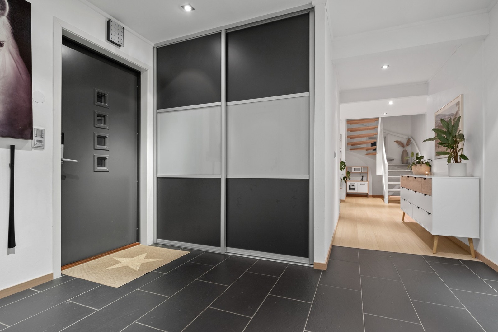 Yttertøy, sko og utstyr ryddes enkelt bort i en plassbygd, romslig skyvedørsgarderobe. Galleribilde