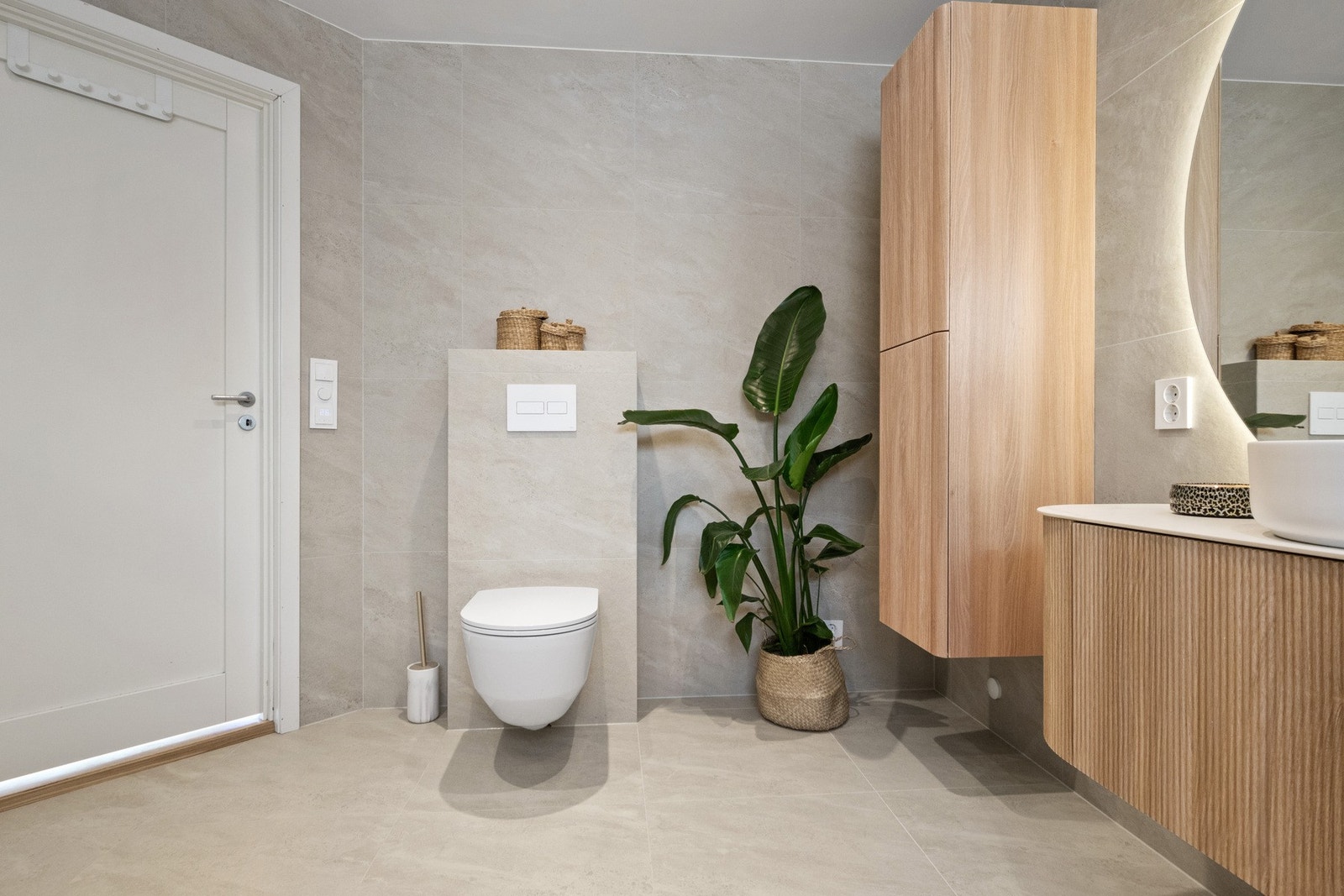 Her er det downlights i himlingen, store, sandfargede fliser på veggene og matchende fliser på gulv med gulvvarme. Galleribilde