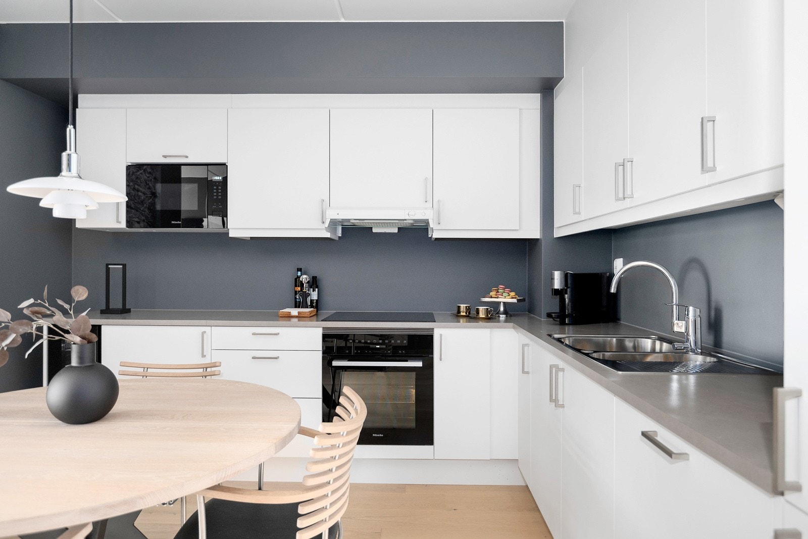 Kjøkkenet har integrerte hvitevarer, herunder kjøleskap med frysedel, stekeovn, platetopp, mikrobølgeovn og vinskap Galleribilde