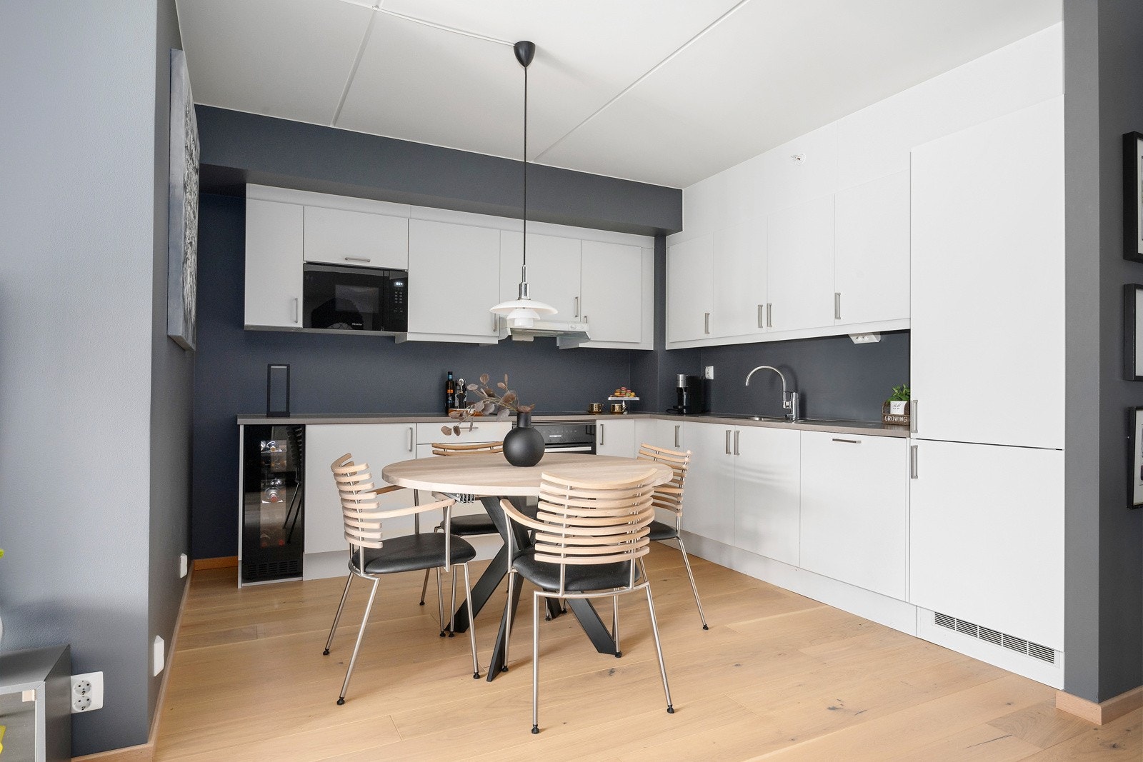 Lekker kjøkkeninnredning med hvite, slette fronter og benkeplate av laminat Galleribilde