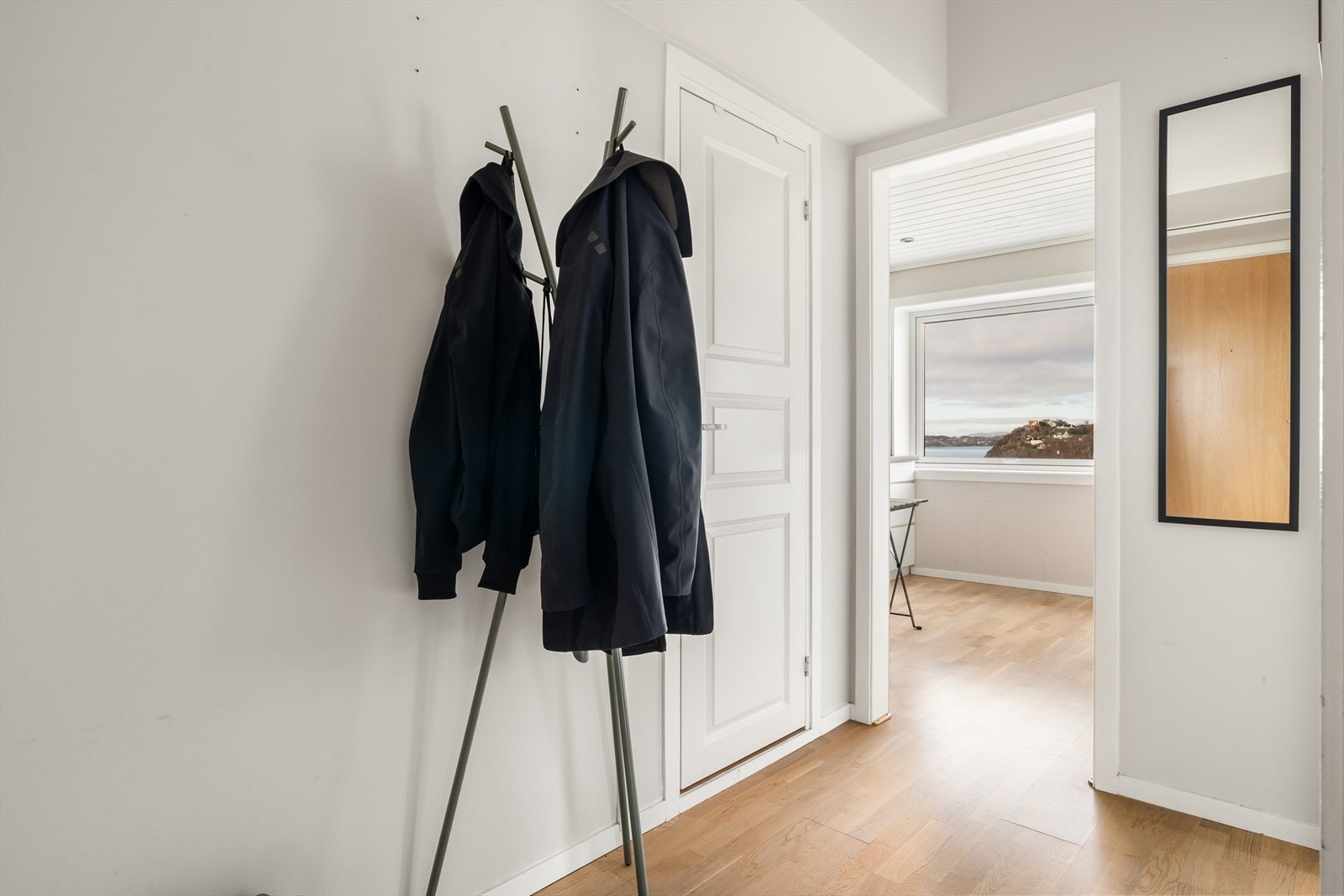 Lys og trivelig entré/gang med eikeparkett på gulv og lysmalte flater på vegger og i himling. God plass til å henge fra seg yttertøy og sko på oppheng. Galleribilde