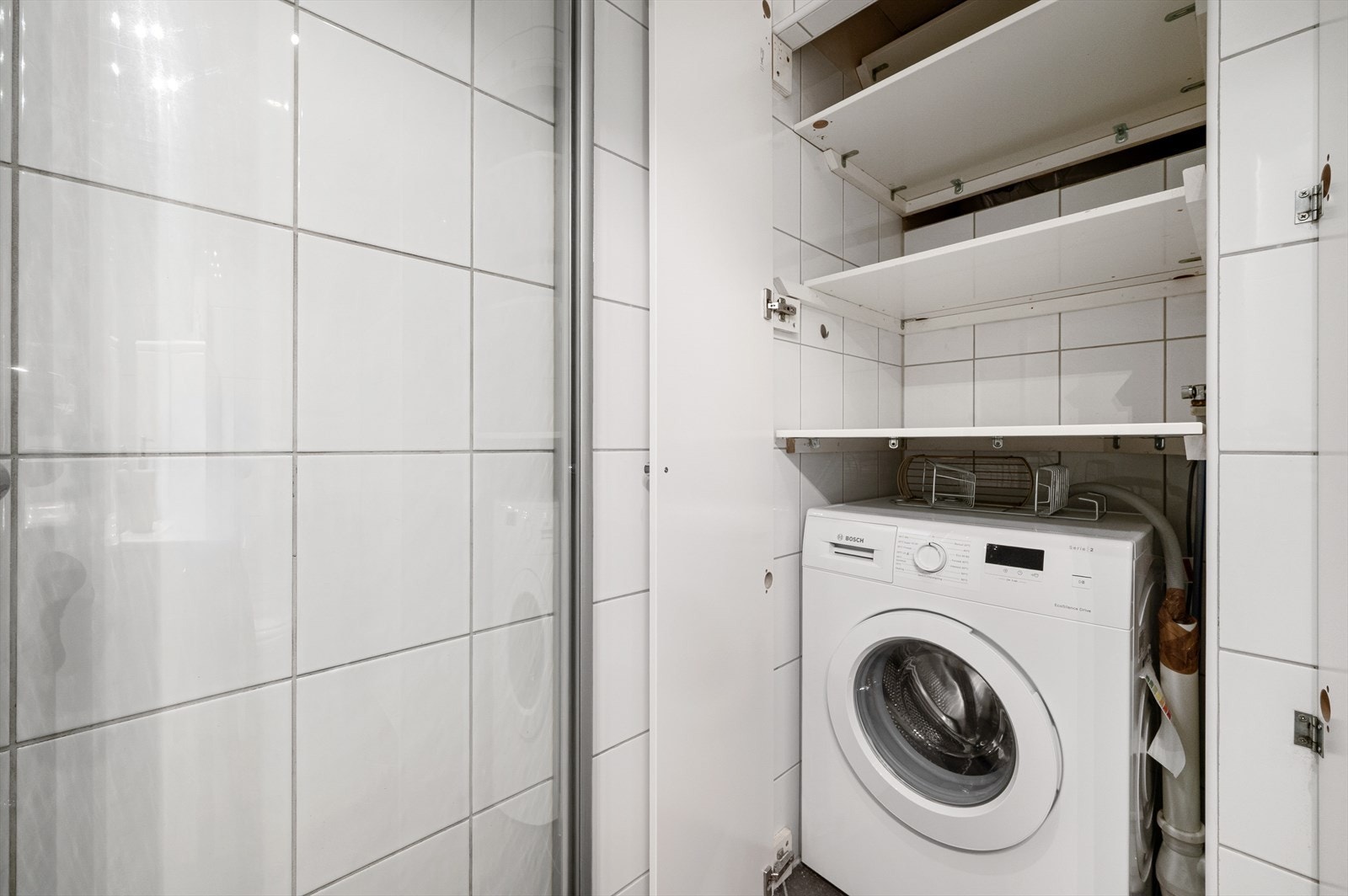 Praktisk nisje på badet hvor en har hyller og plass til vaskmaskin. Galleribilde