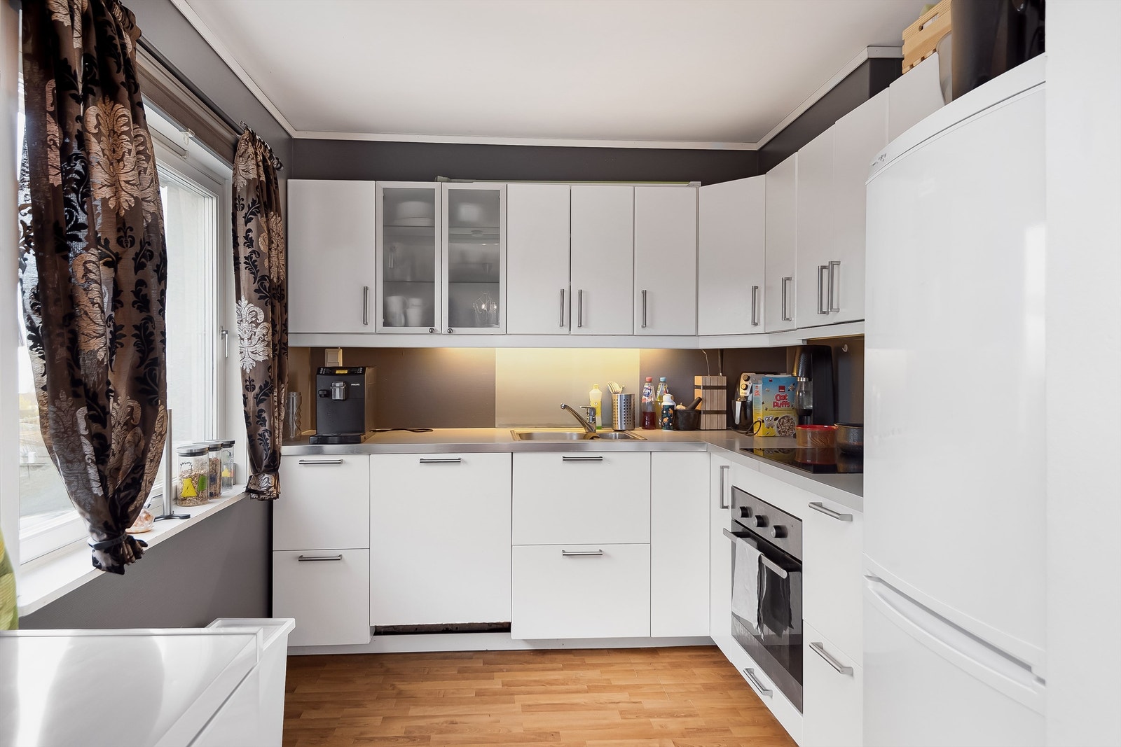 Kjøkkenet er innredet med lyse slette flater og benkeplate av laminat. Galleribilde