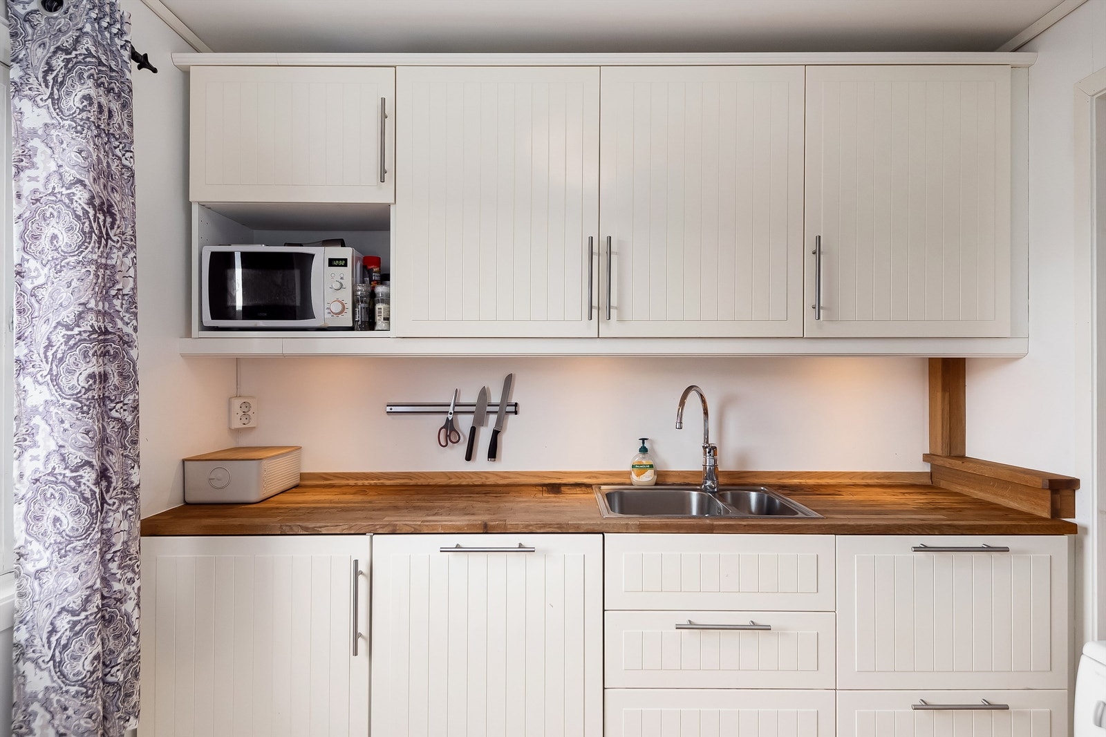 Pen kjøkkeninnredning fra 2015 med lyse flater og benkeplate i kontrast. Galleribilde