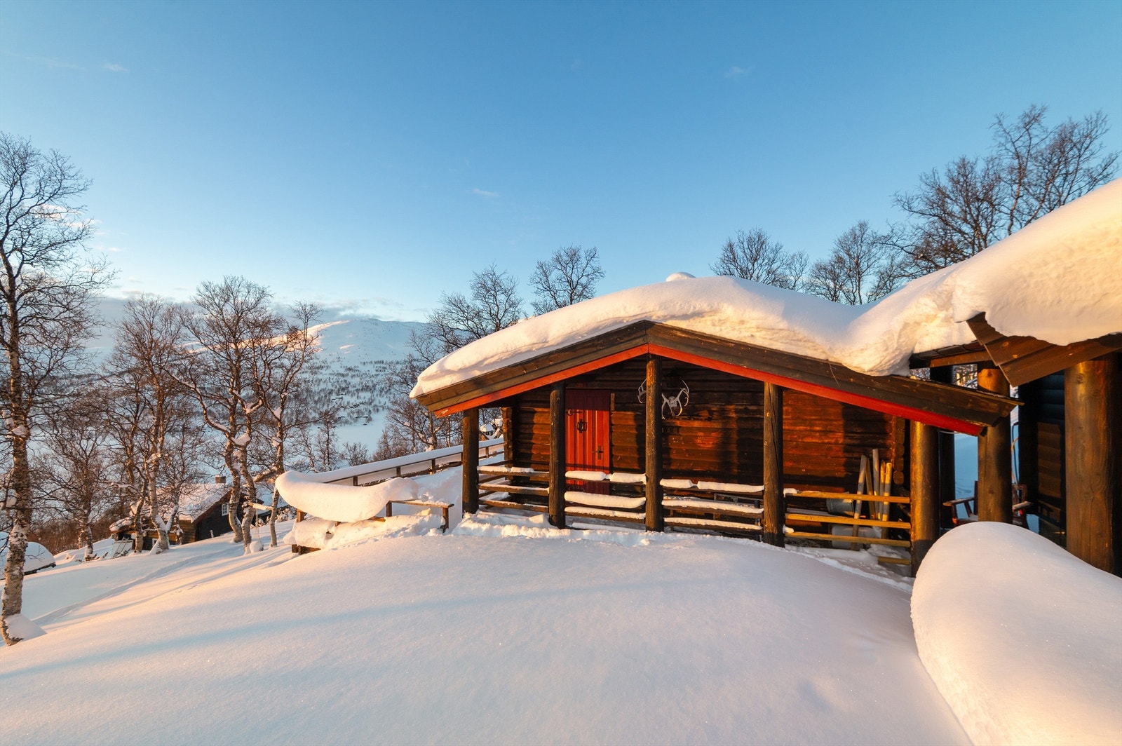Annekset er bygget tett inntil hytta fra 1965, og danner et lite tun sammen med boden i bakkant av bildet. Galleribilde