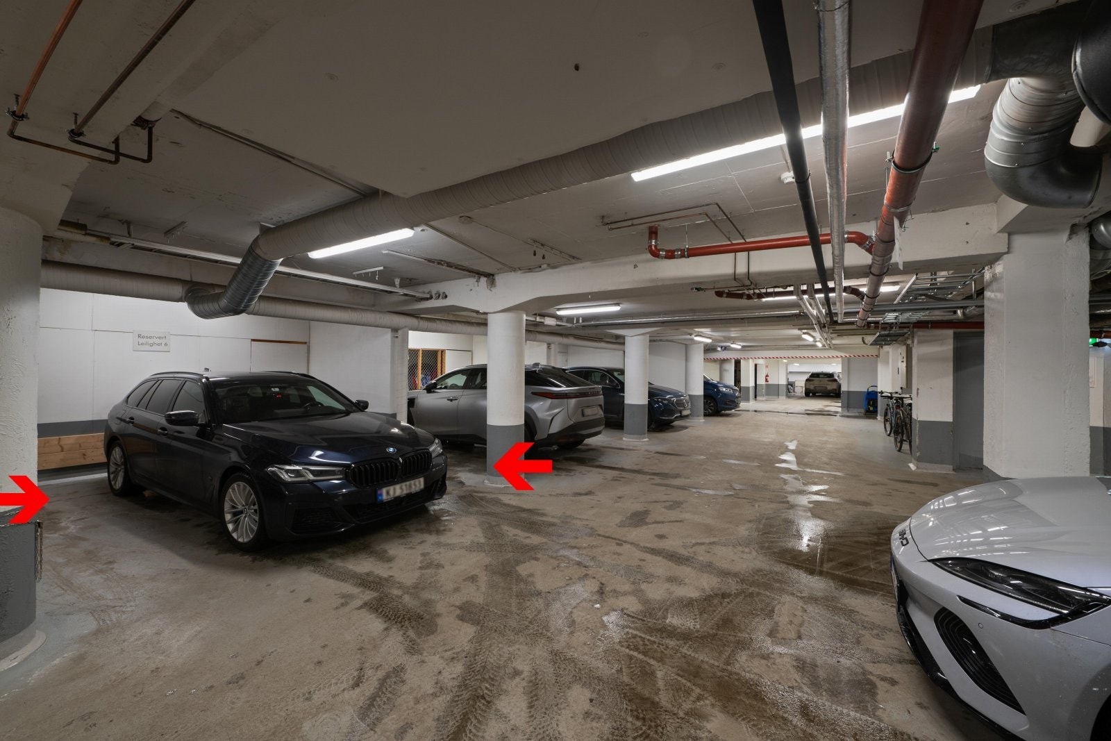 Parkeringsplass med bod i bakkant i byggets underetasje. Galleribilde