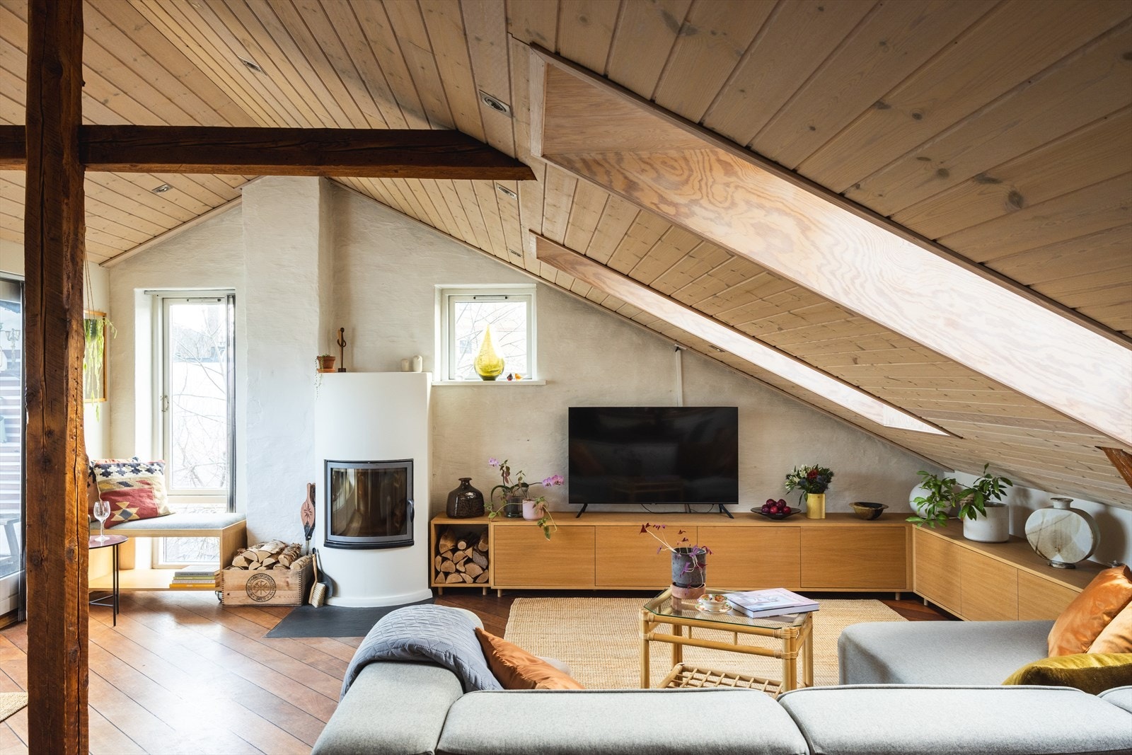 Synlige trebjelker, skråtak med 2.82 meter under mønet, samt vinduer på tre sider, inkludert i tak Galleribilde