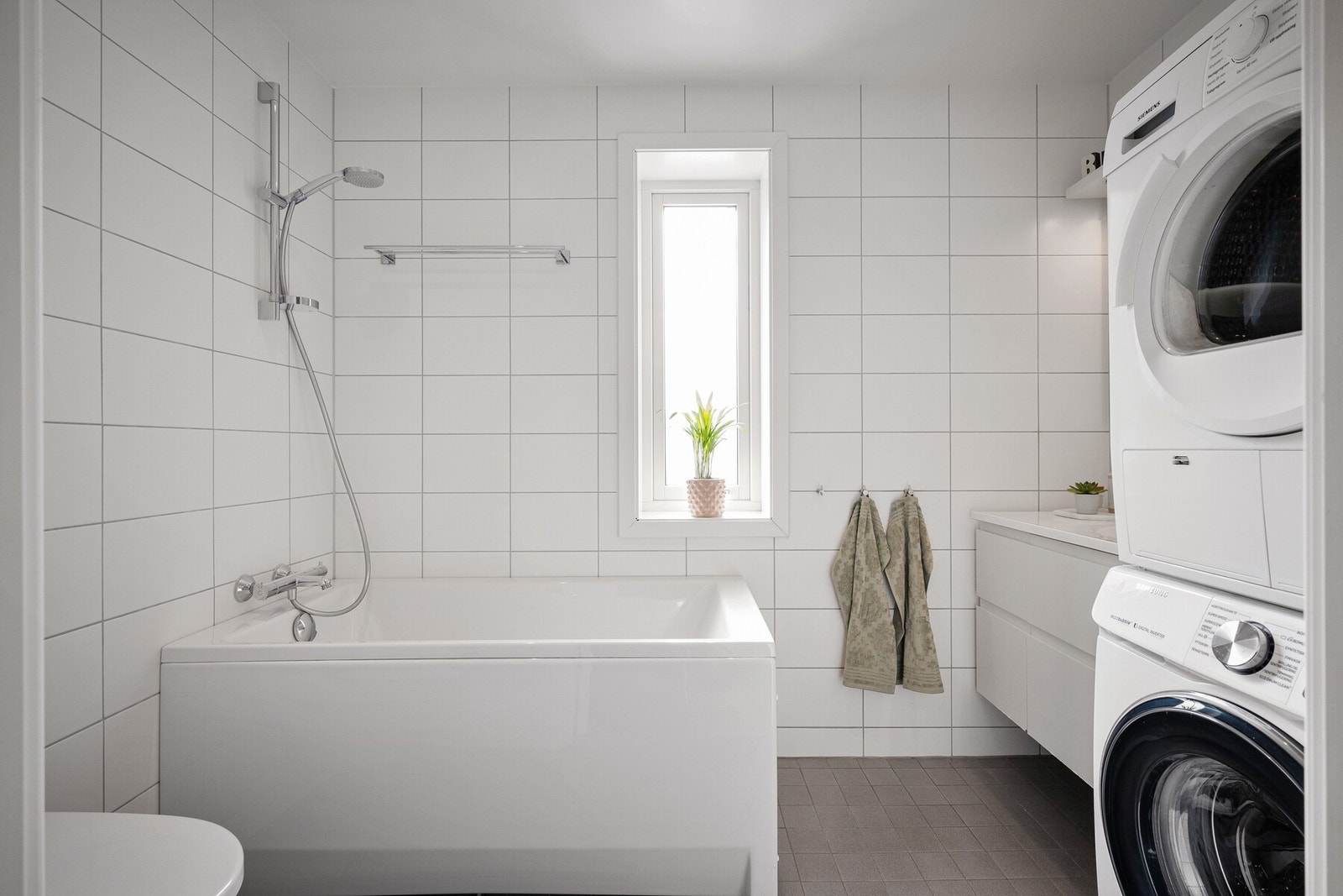 Det ene badet har både badekar og dusj, samt opplegg for vaskemaskin og tørketrommel. Galleribilde