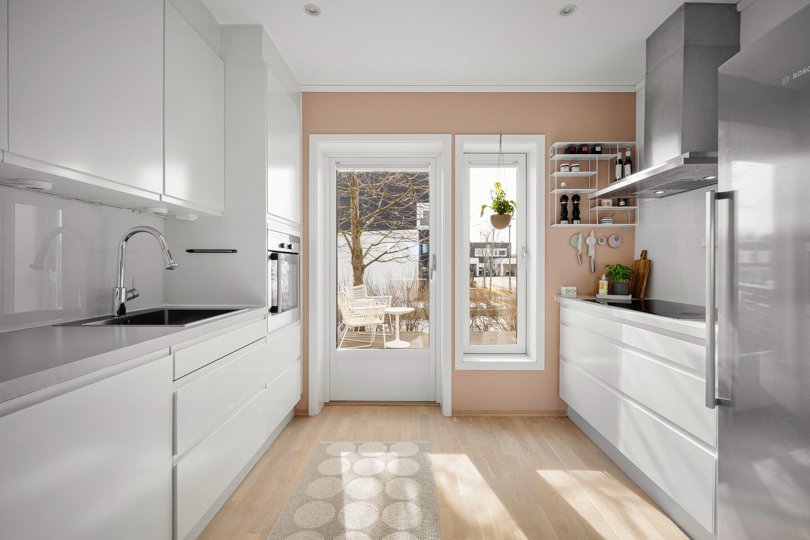 Kjøkkenet er utstyrt med integrerte hvitevarer, inkludert stekeovn, induksjonstopp, og oppvaskmaskin, som sikrer en sømløs matlagingsopplevelse. Galleribilde