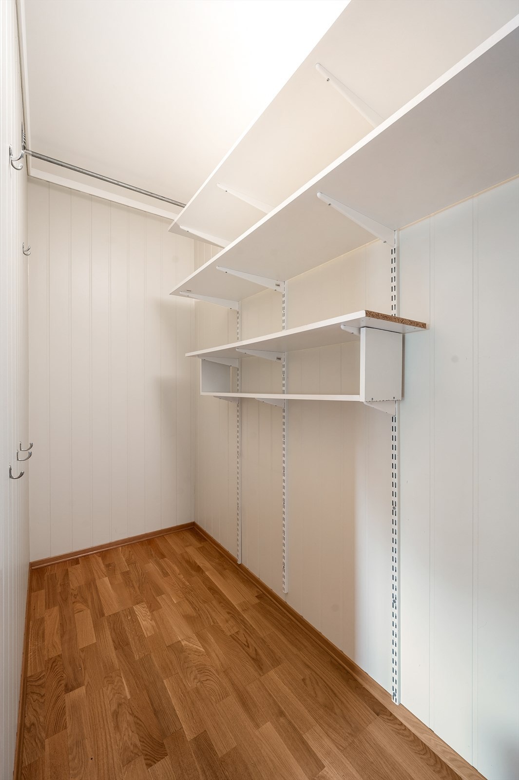 Walki-in closet eller bod på innsiden av det ene soverommet med hyller Galleribilde