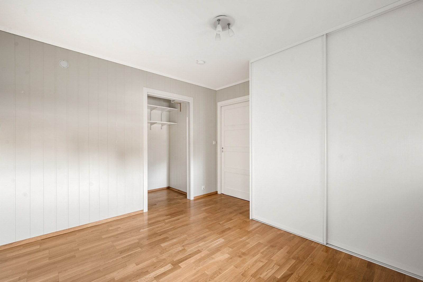Soverom med skyvedørsgarderobe og walk-in closet/bod Galleribilde