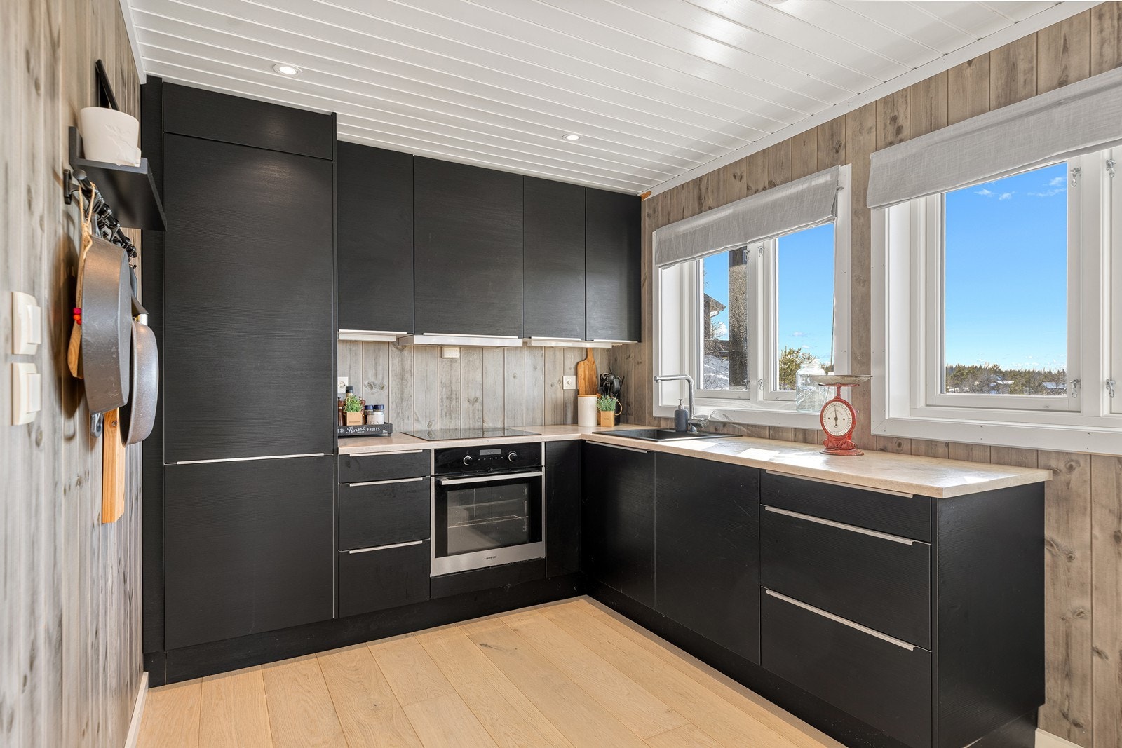 Kjøkkenet er både praktisk og elegant, med parkettgulv, laminerte fronter og benkeplate Galleribilde