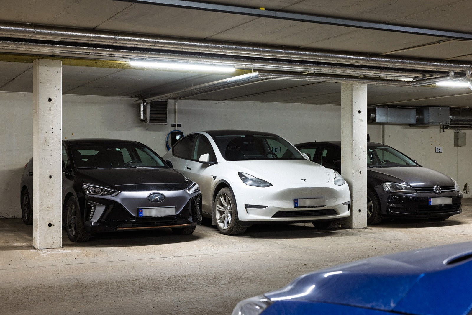 Nåværende eiere leier garasjeplass i felles anlegg, hvor den hvite Teslaen står. Utleier bekrefter at ny leieavtale kan inngås med nye eiere. Galleribilde
