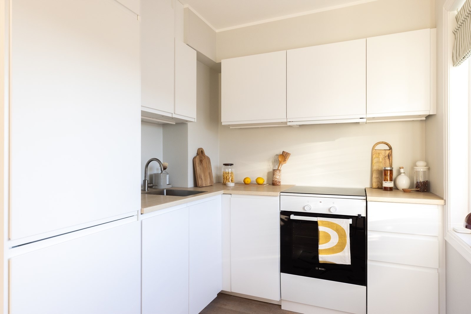 Pen kjøkkeninnredning fra 2023 med glatte laminert fronter Galleribilde