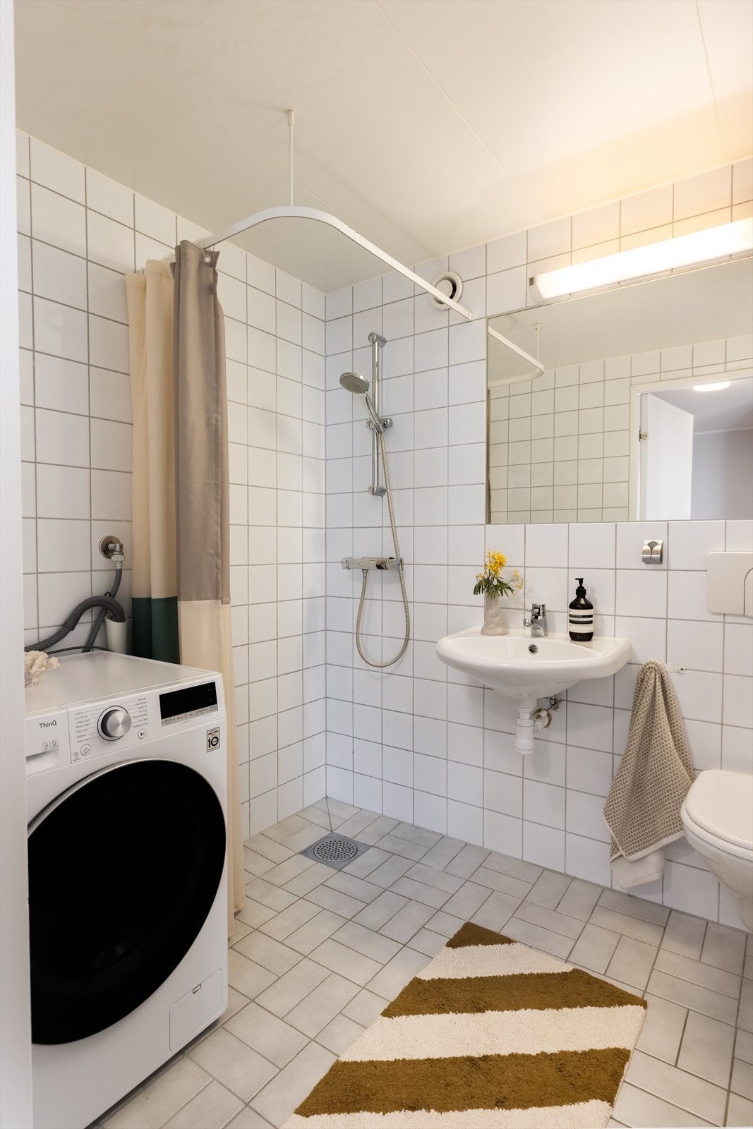 Badet er romslig og byr på godt med lagringsplass over vaskemaskinen. Det er også mulighet for å plassere en tørketrommel over vaskemaskinen om ønskelig Galleribilde