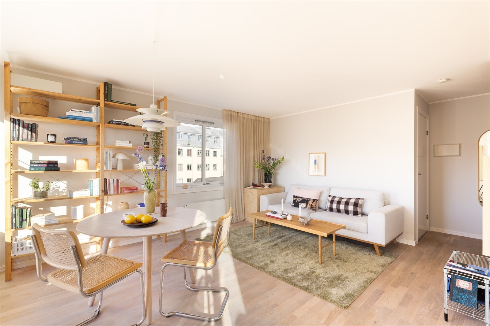 Den romslige stuen har god plass til både sofagruppe og spisebord. Store vindusflater slipper inn rikelig med naturlig lys og skaper en lys og luftig romfølelse Galleribilde