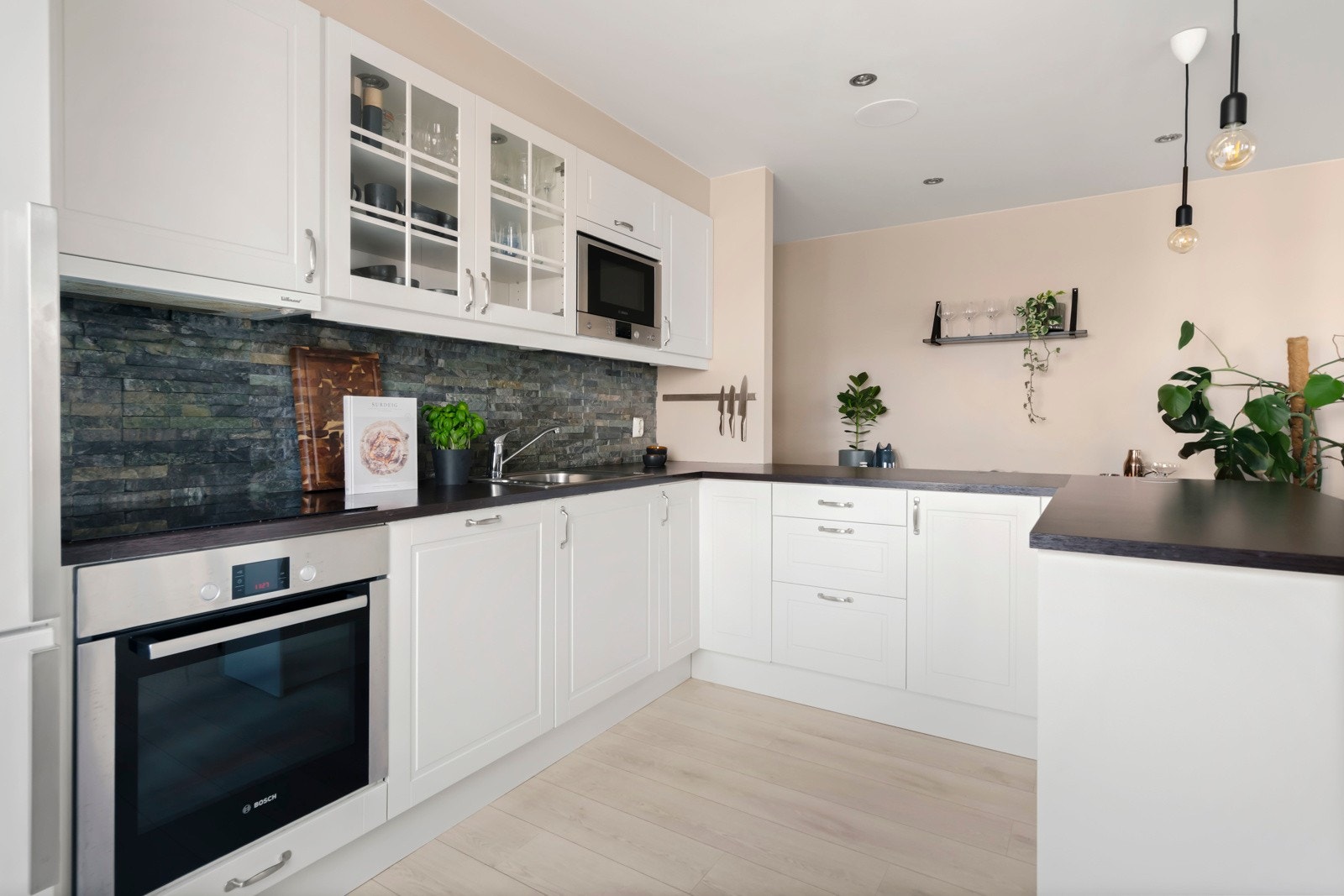 Rikelig med oppbevaringsplass i kjøkkeninnredningen. Integrert komfyr, koketopp, oppvaskmaskin og mikrobølgeovn gir et strømlinjeformet og delikat uttrykk. Galleribilde