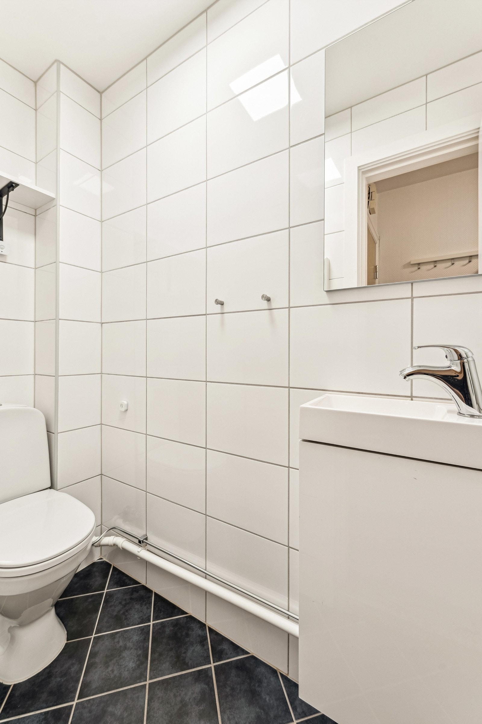 Separat wc med gulvvarme, servant med underskap, speil og toalett. Galleribilde