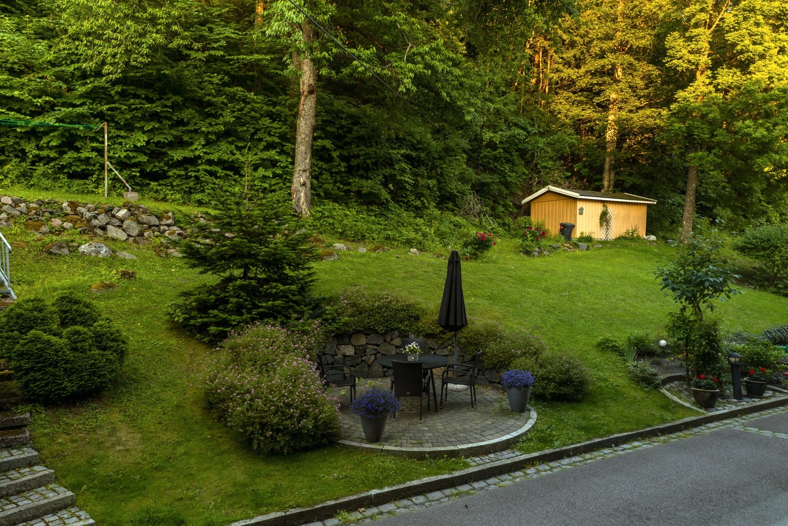 Tomten er pent opparbeidet med gress, beplantning, busker, trær m.m. Galleribilde