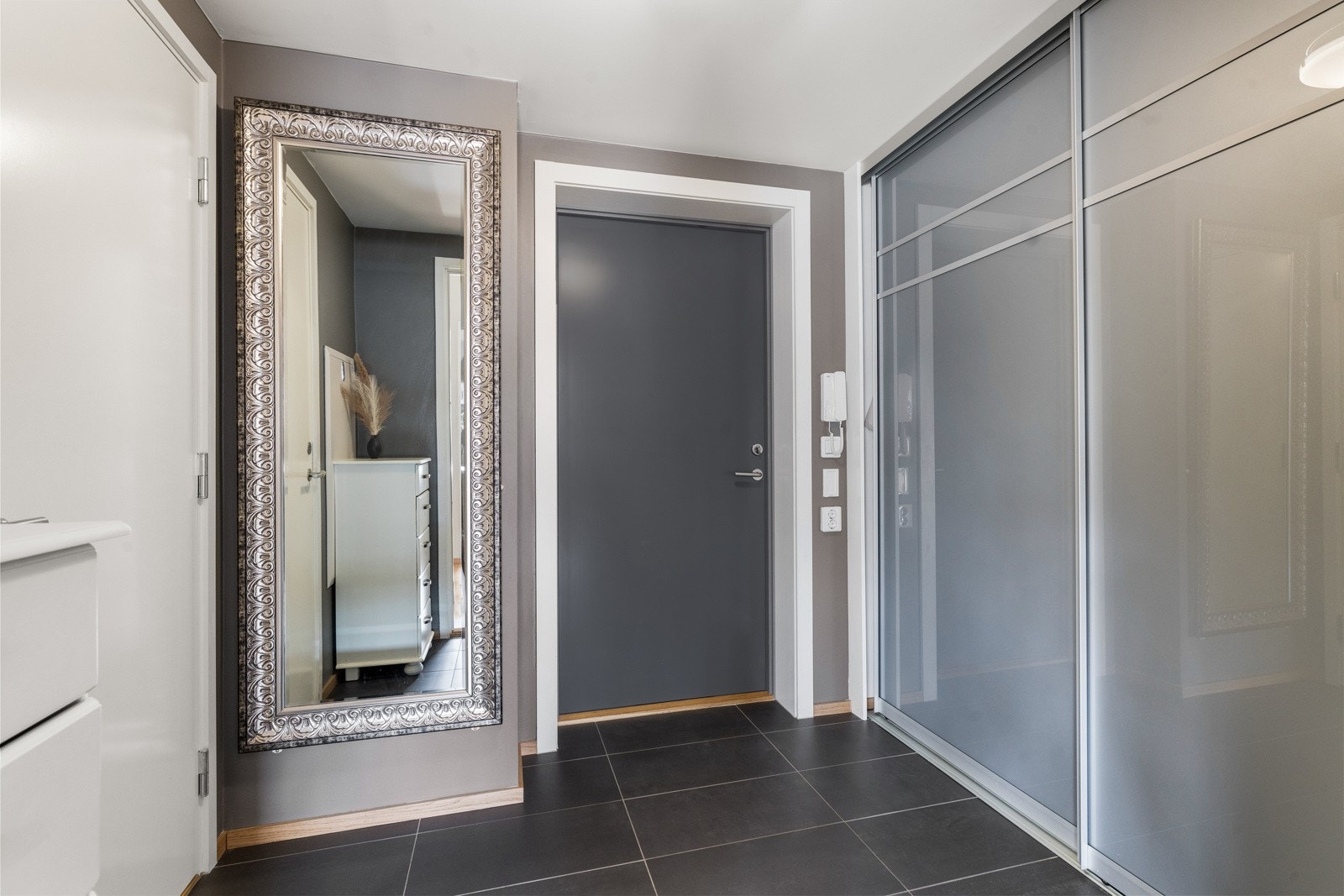 Flislagt entré med gulvvarme, og skyvedørsgarderobe for yttertøyet. Galleribilde