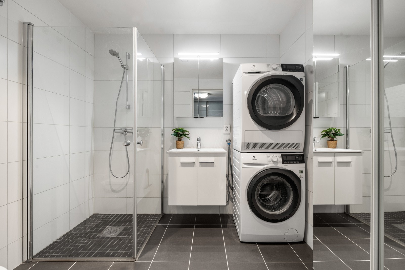 Flott baderom med servantskap, speilskap m/lys, vegghengt toalett, dusjhjørne med innfellbare dører og opplegg for vaskemaskin. Galleribilde