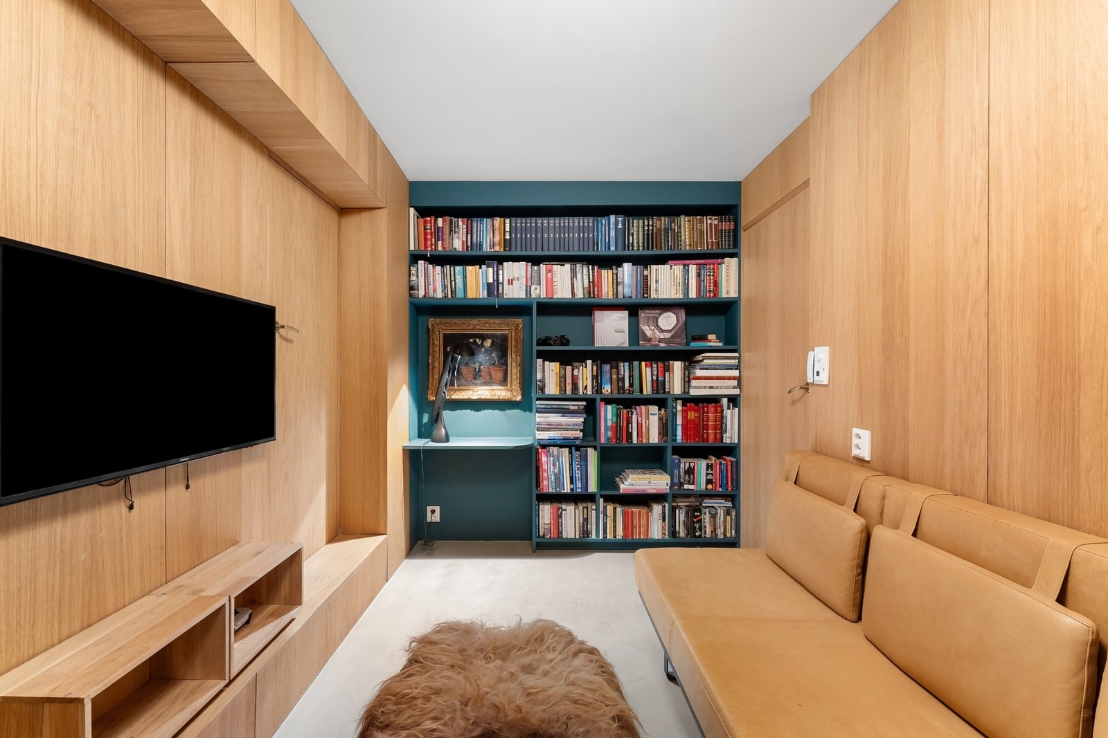 Snekkertilpasset tv-stue/bibliotek med innfelte dører skjult i vegg. Galleribilde