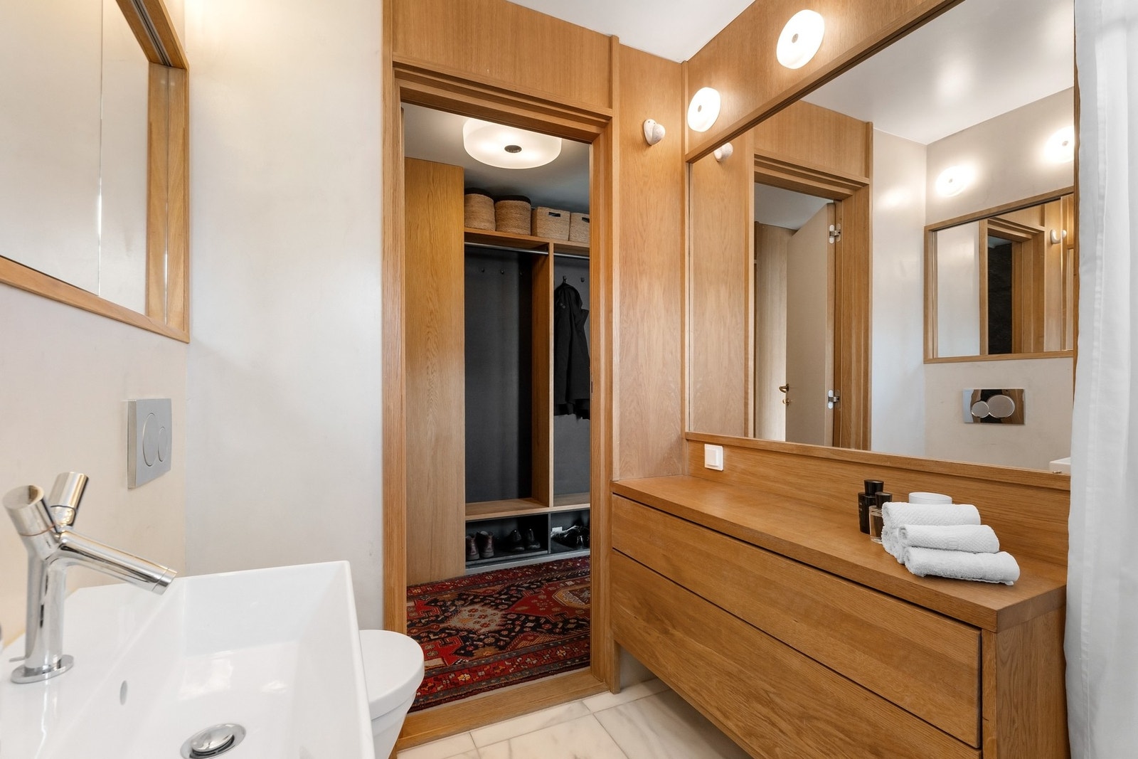 Innredningen er gjennomtenkt med elegante detaljer i eik, og inkluderer servant, benkeskap med praktisk skuffeløsning, samt et stilrent speil og belysning. Galleribilde