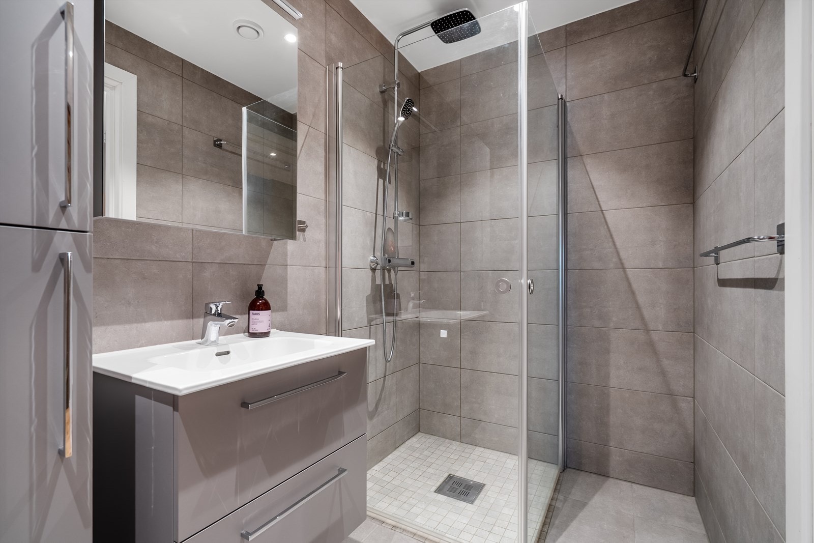 Begge badene har moderne med grå fliser, vannbåren gulvvarme og regnfallsdusj. Galleribilde