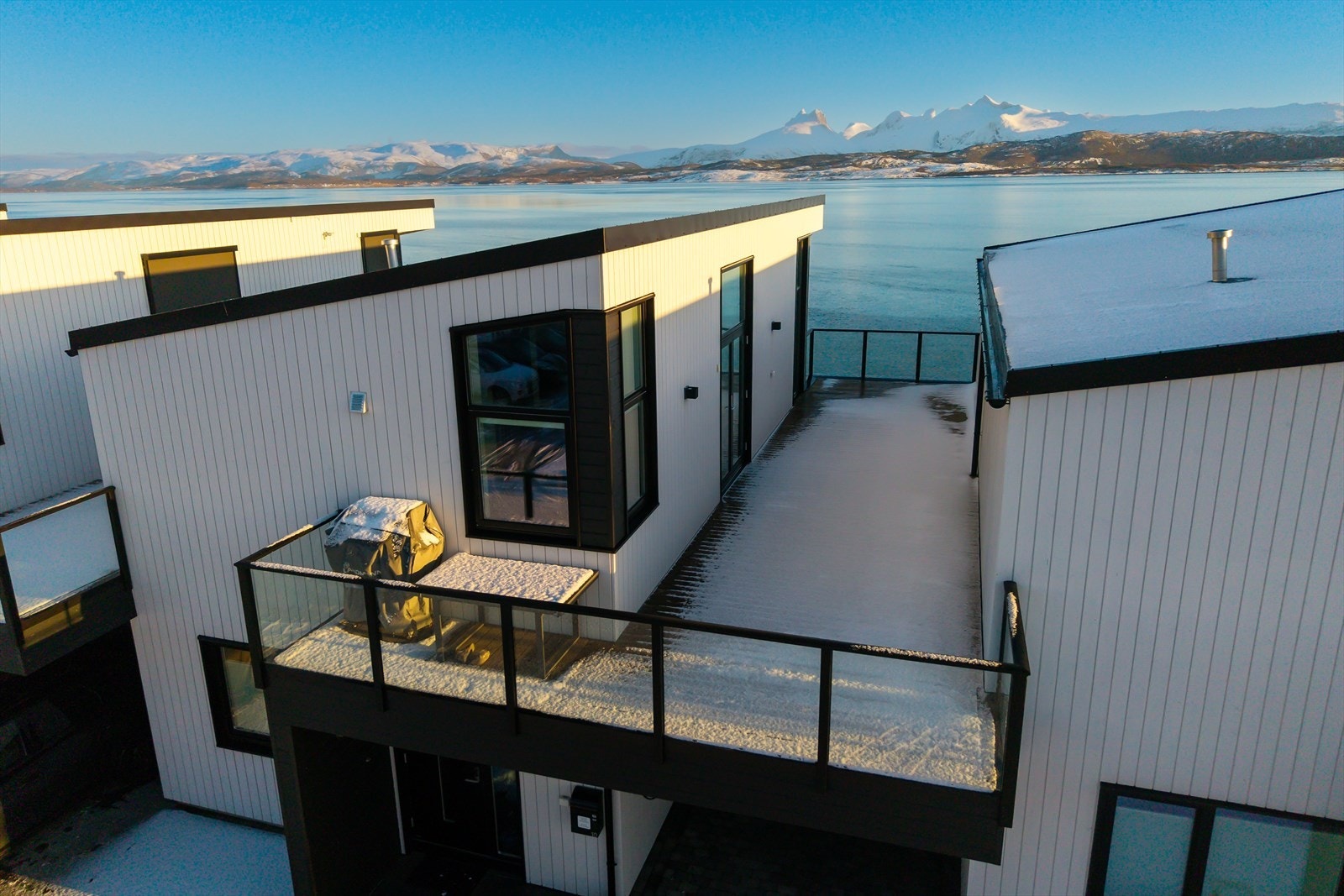 Takterrassen over carporten ligger mot sør/vest/nord og har glassrekkverk mot gårdsplassen og sjøsiden.
Gode solforhold på formiddag og ettermiddag på sommerstid. Galleribilde