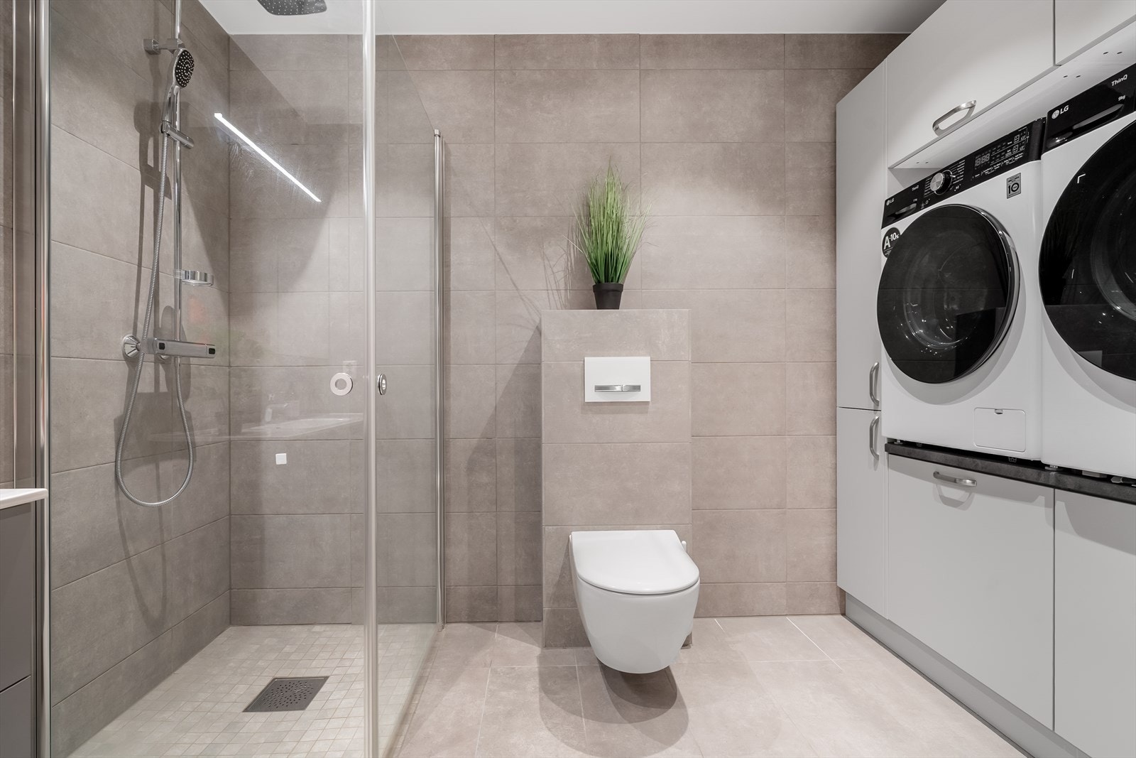 Badet i underetasjen har en fin innredning med nisje for vaskemaskin og tørketrommel i god arbeidshøyde. Galleribilde