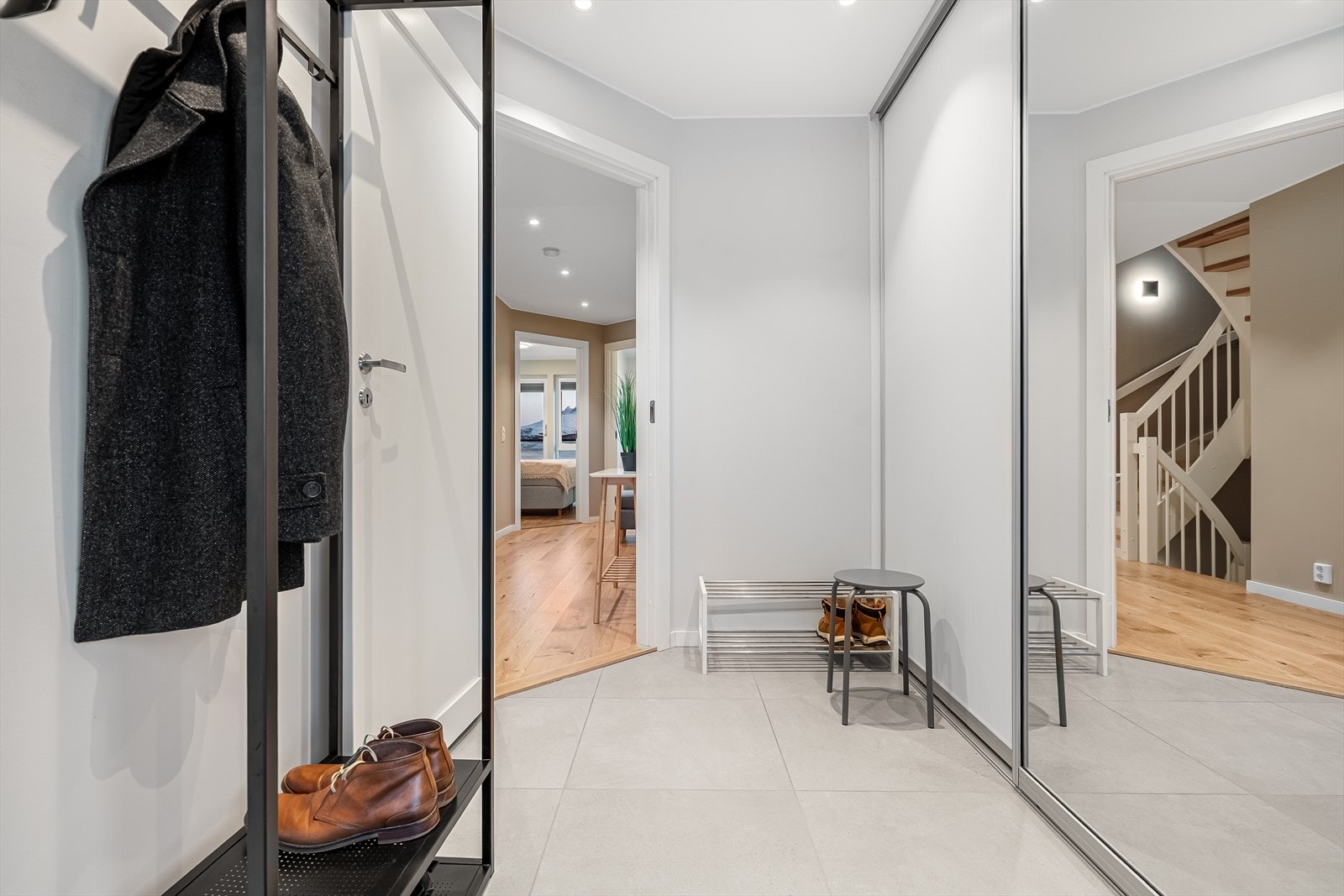 Entreen er lys og innbydende med fliser på gulvet, vannbåren gulvvarme og stor skyvedørsgarderobe til yttertøy og sko. Galleribilde