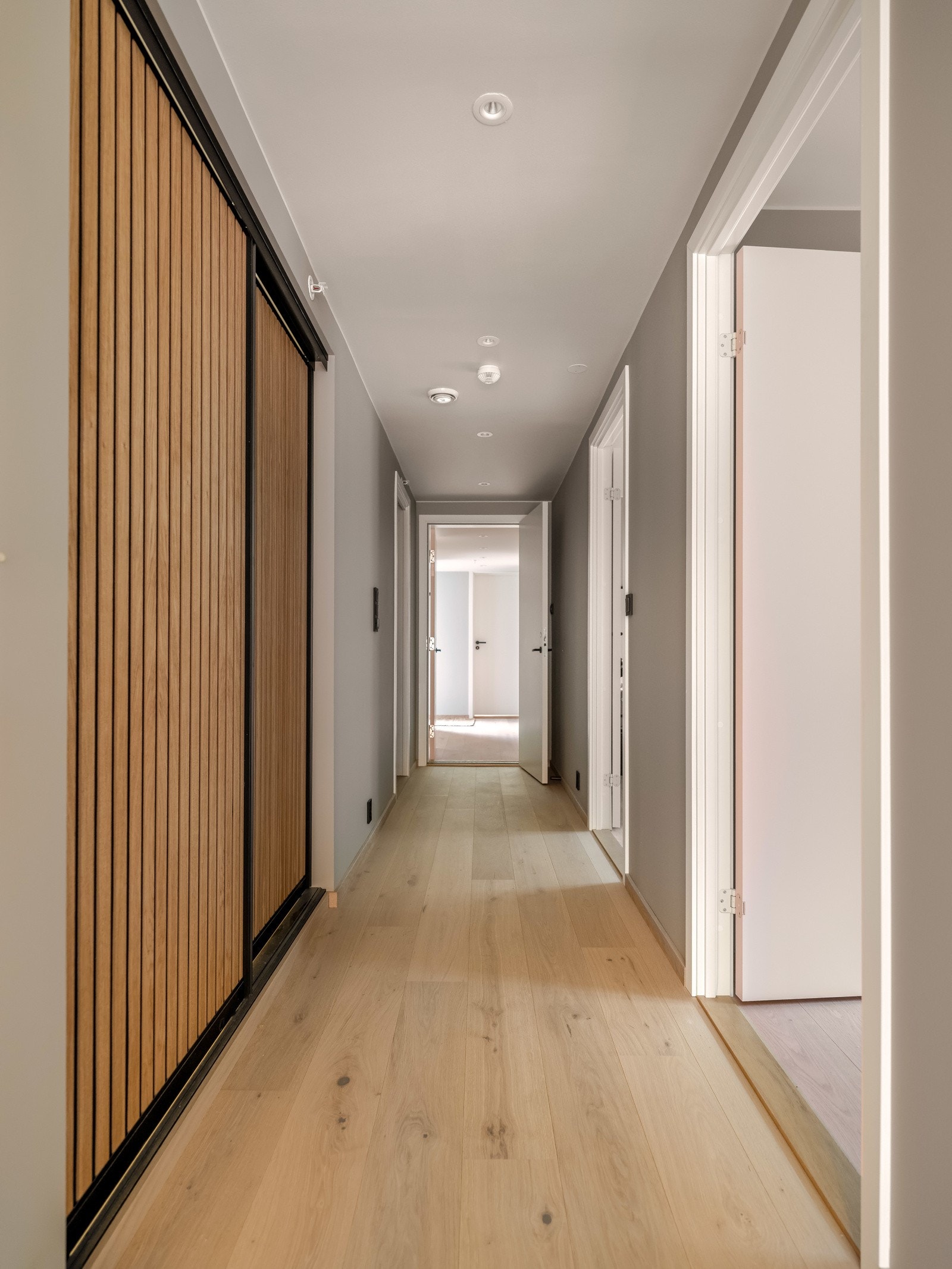 Gangen leder til leilighetens bad og soverom, samt mot bileiligheten. Her har man garderobe med god oppbevaringsplass og rom for vaskemaskin. Galleribilde